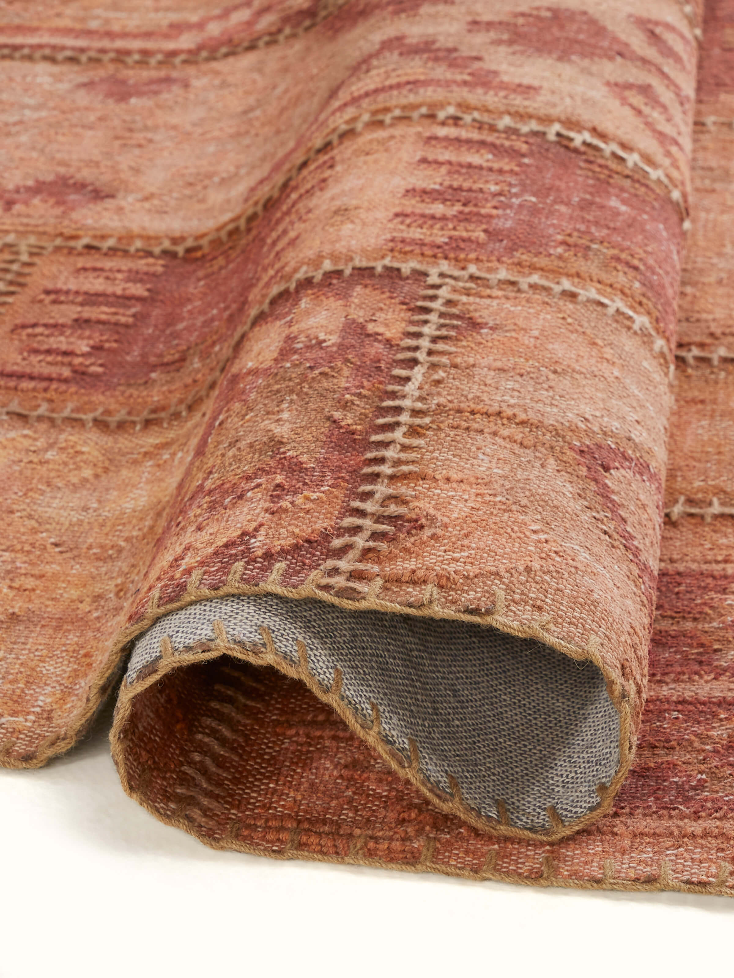 Perspective view of Kilim patchwork antique rust wool panja dhurrie displaying the overall design and color harmony of the wool dhurrie.