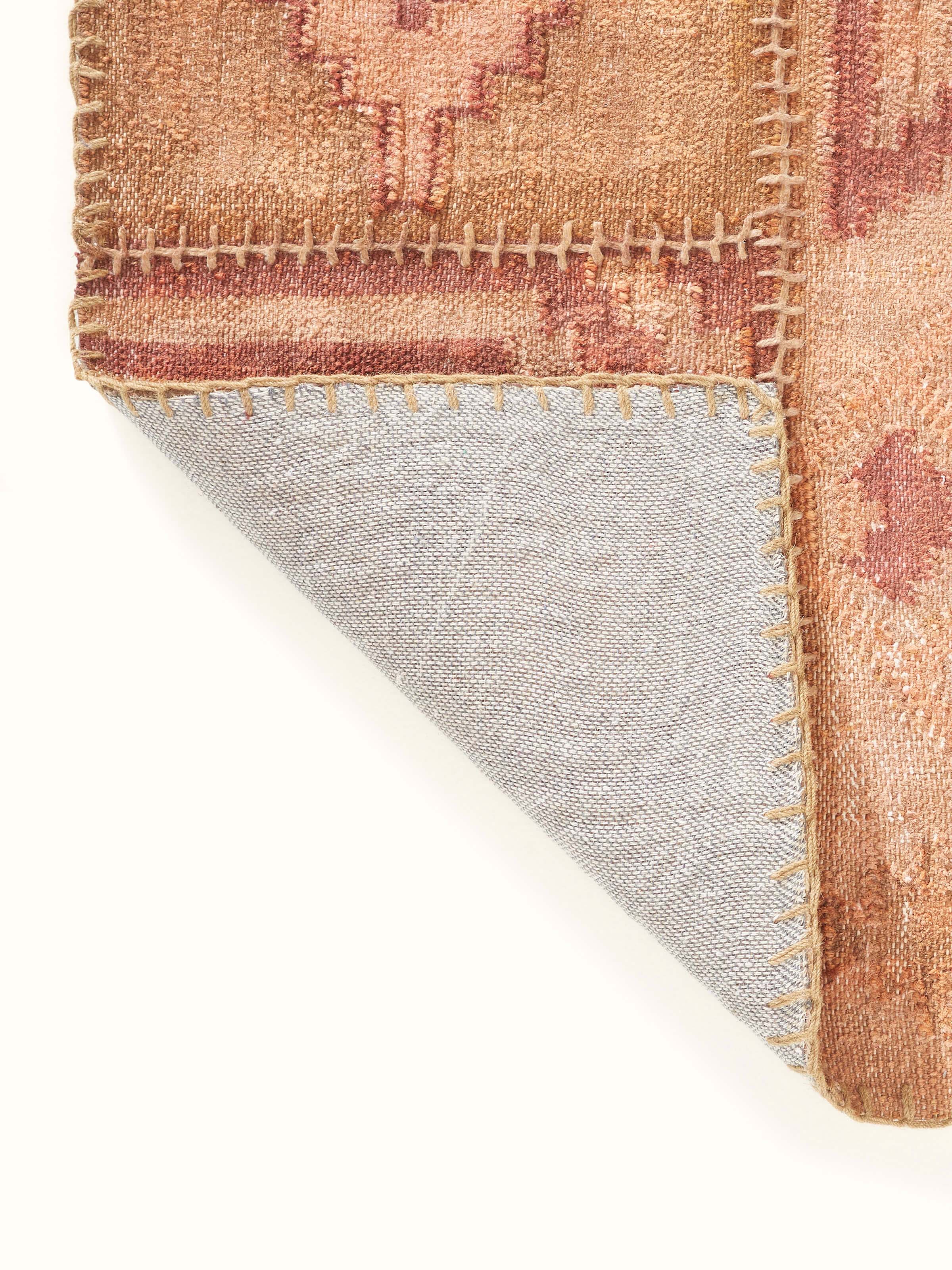 Close-up of Kilim patchwork antique rust wool panja dhurrie showcasing the rich rust color and detailed patchwork design.