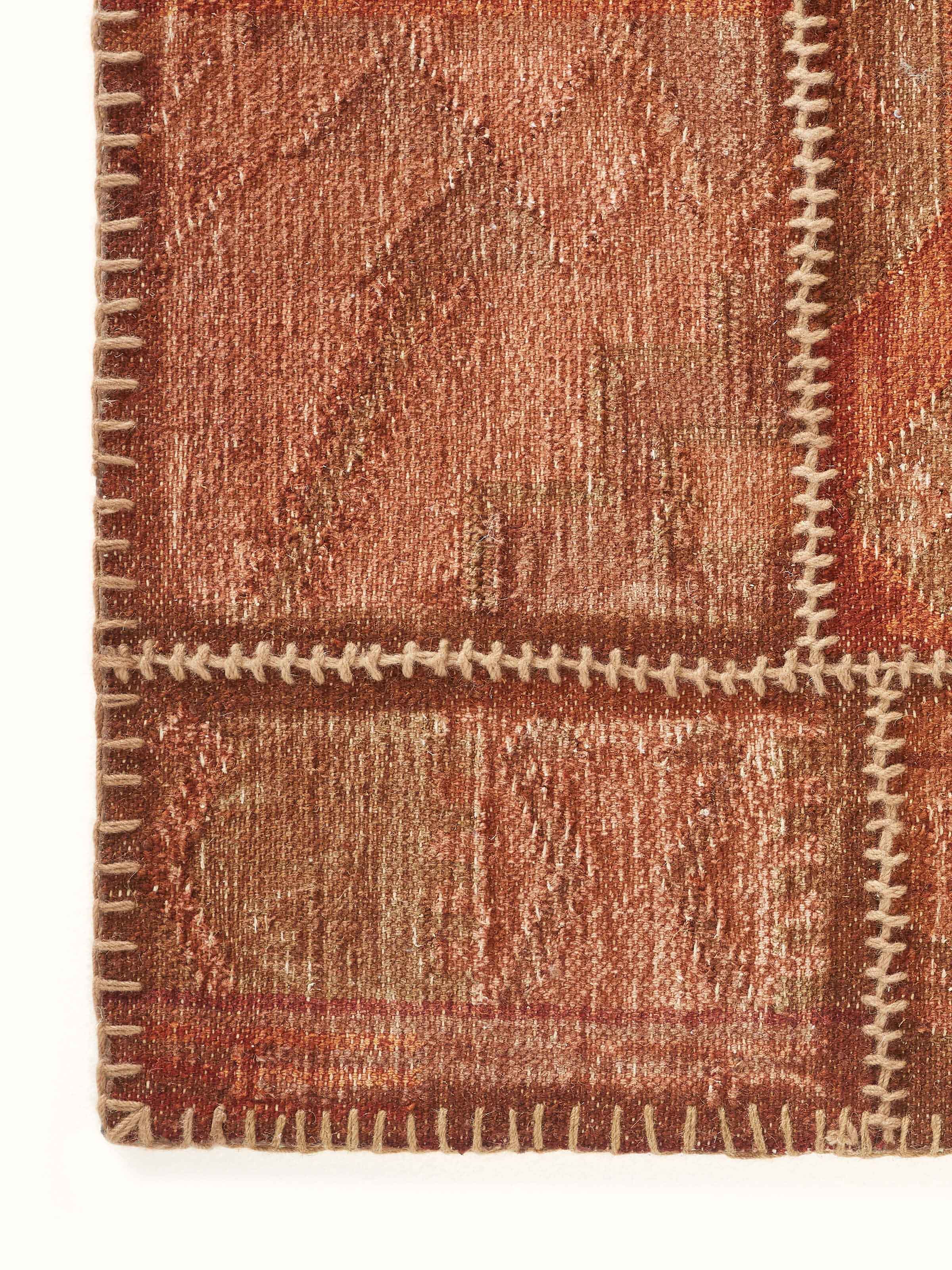 Close-up of Kilim patchwork antique red wool panja dhurrie, focusing on the detailed pattern and fabric quality