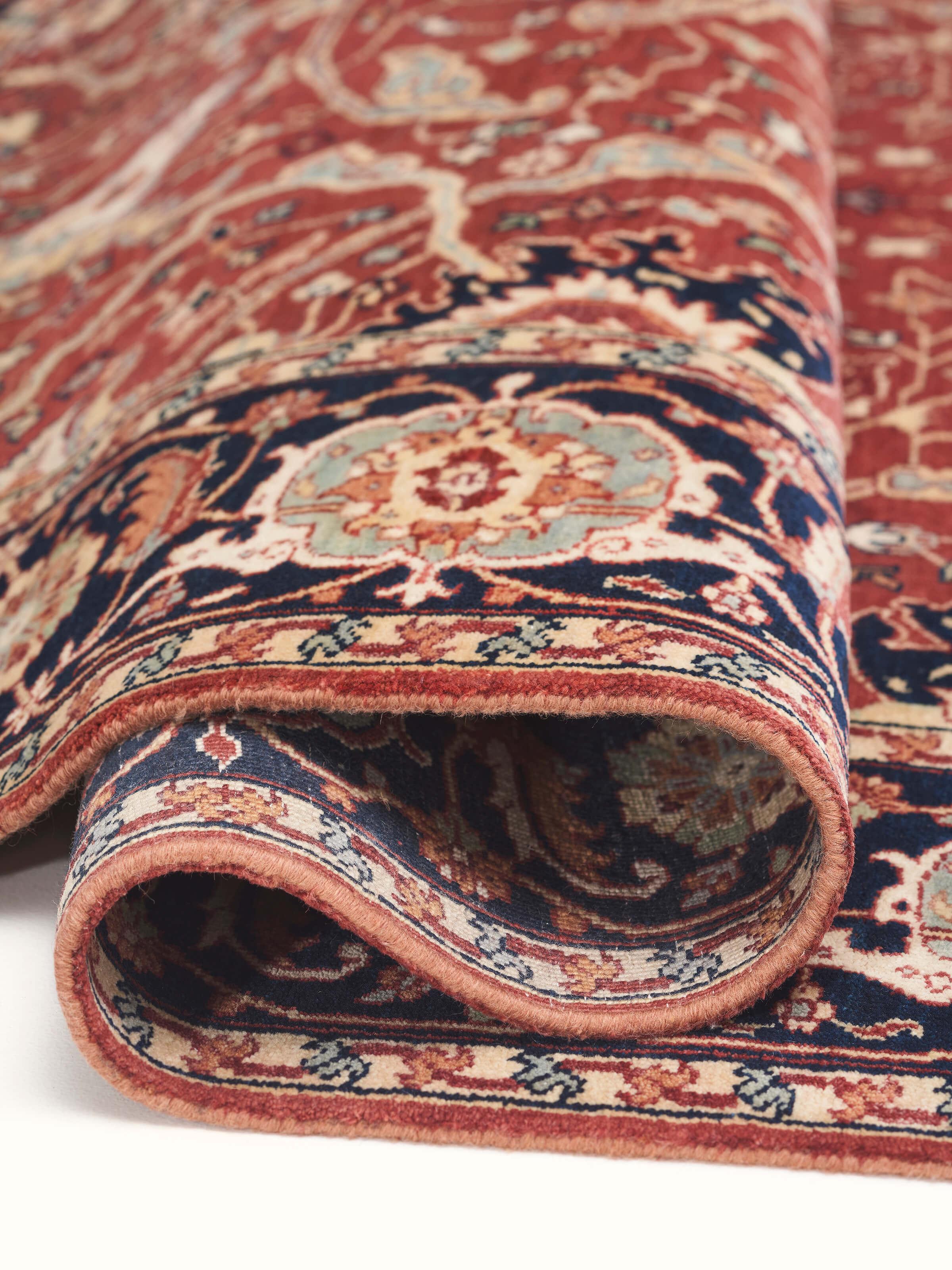 Traditional Heriz red Bhadohi wool hand-knotted rug, emphasizing the luxurious wool texture and traditional design.