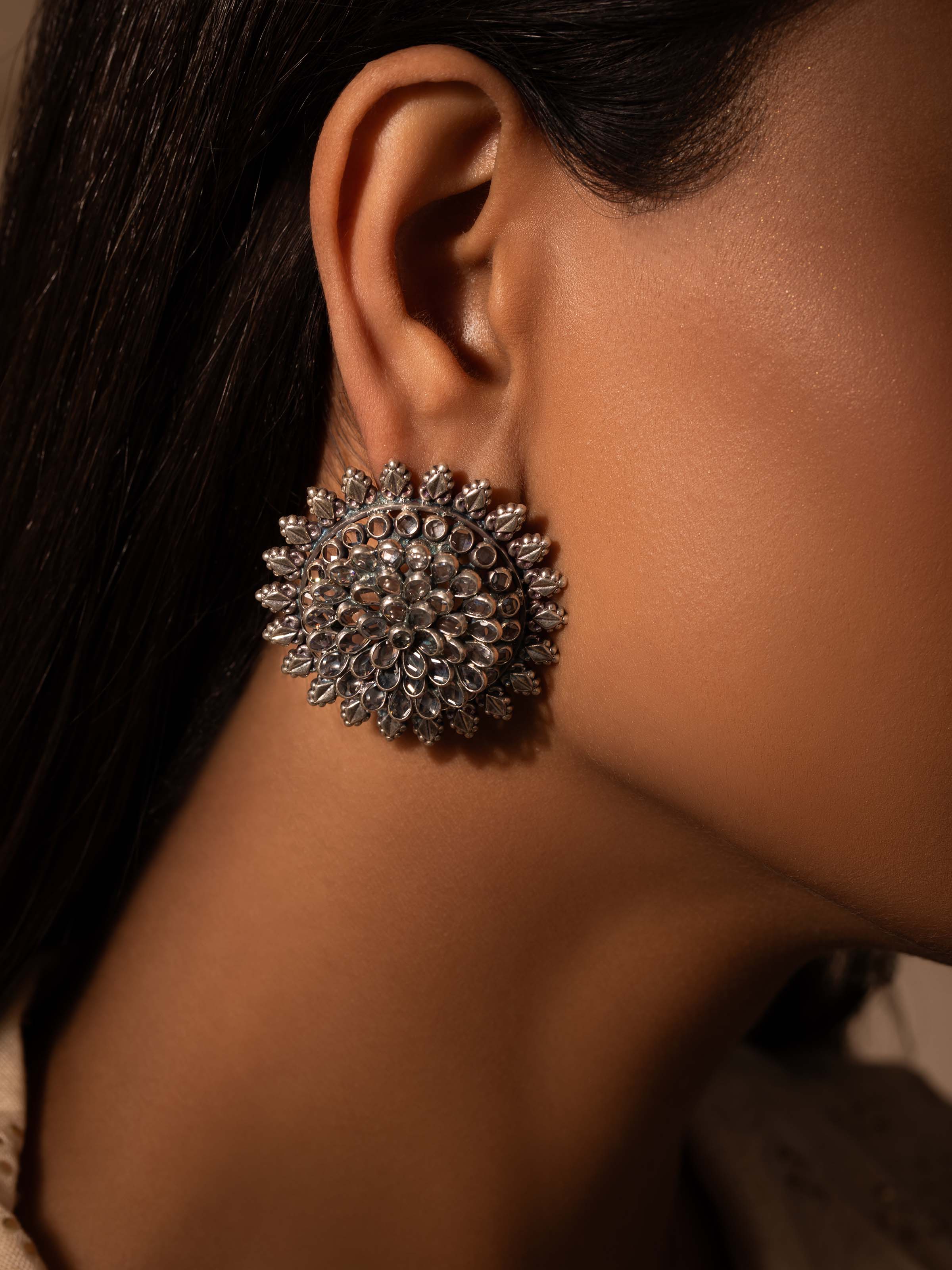 Close-up view of Smithing Stud Earrings showcasing fine silver detailing and design.