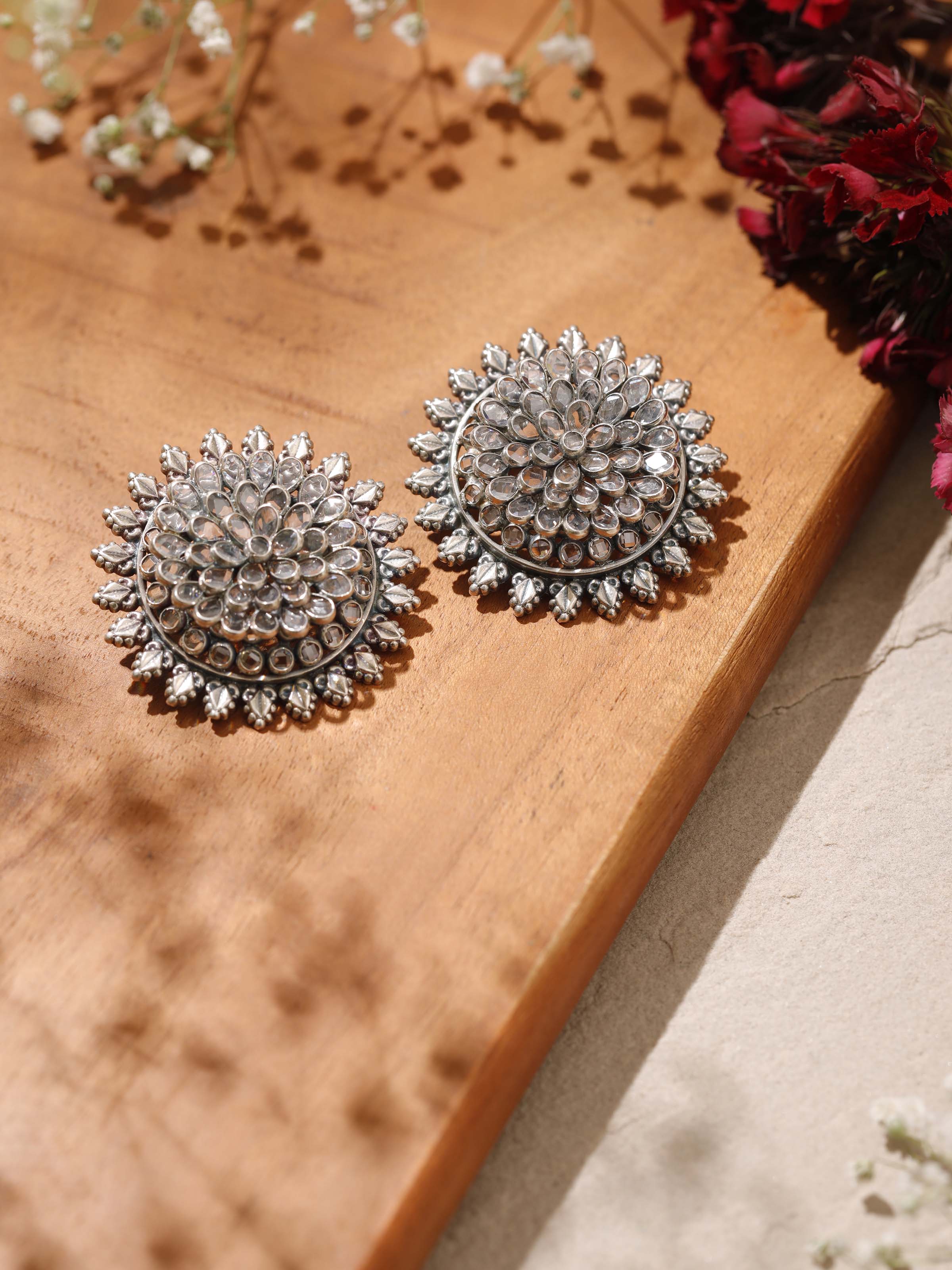 Angled view of Smithing Stud Earrings highlighting intricate silver craftsmanship.