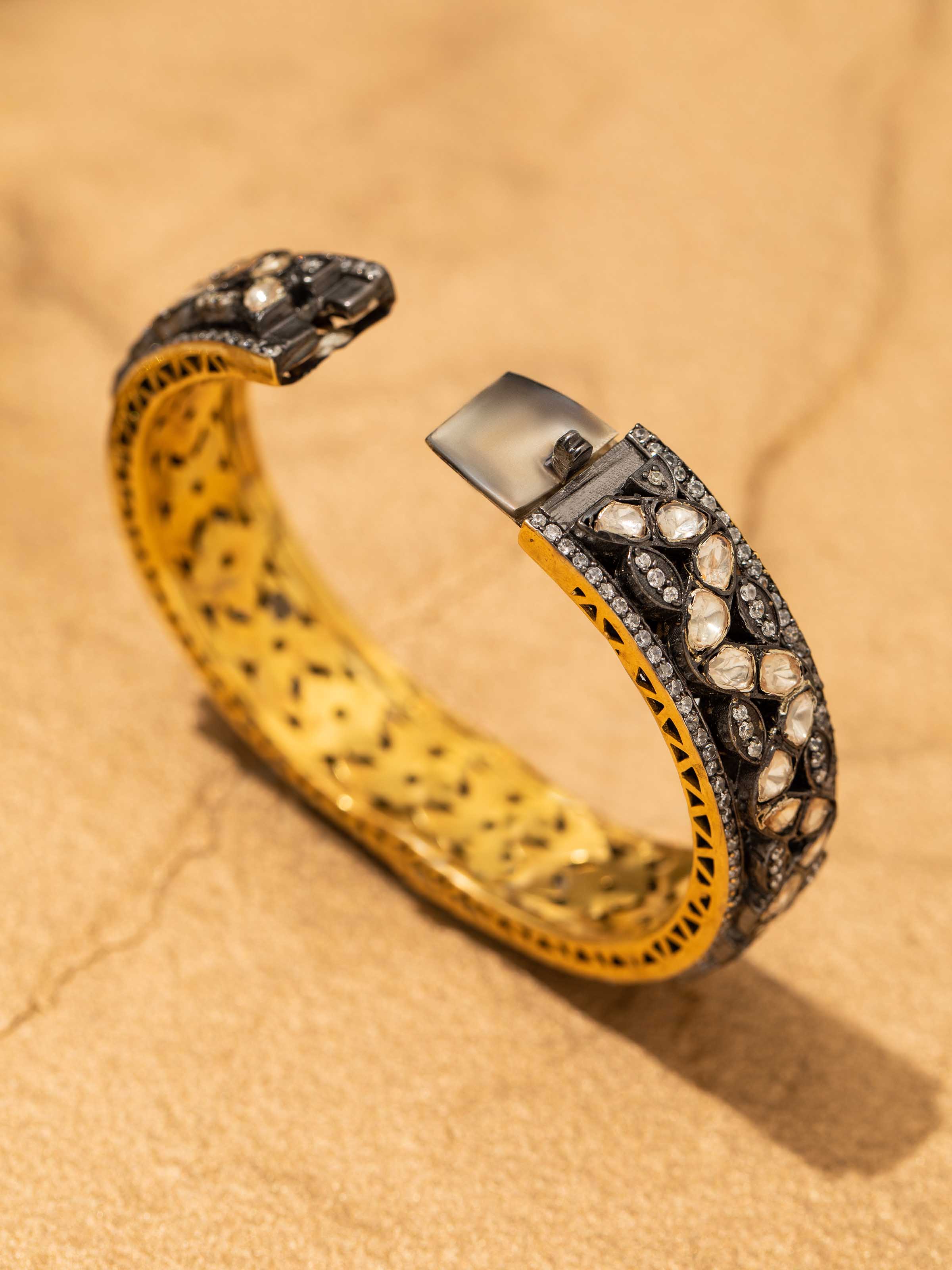 Detailed view of silversmithing bangle with emphasis on metal texture and finish.