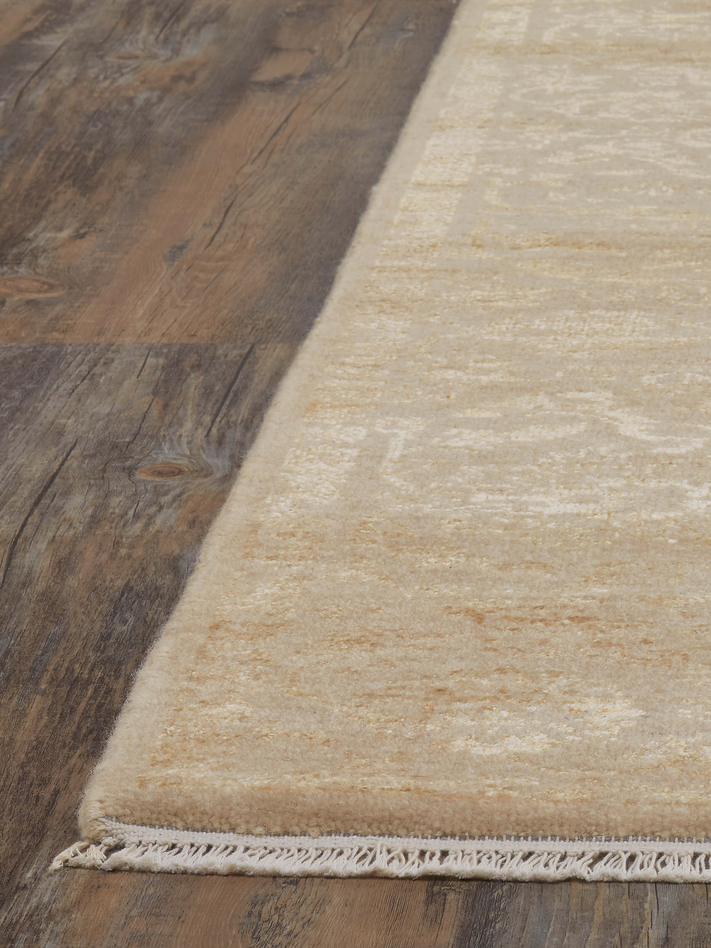 Angle view of the distressed gold Agra rug, emphasizing the plush wool and viscose texture and elegant design