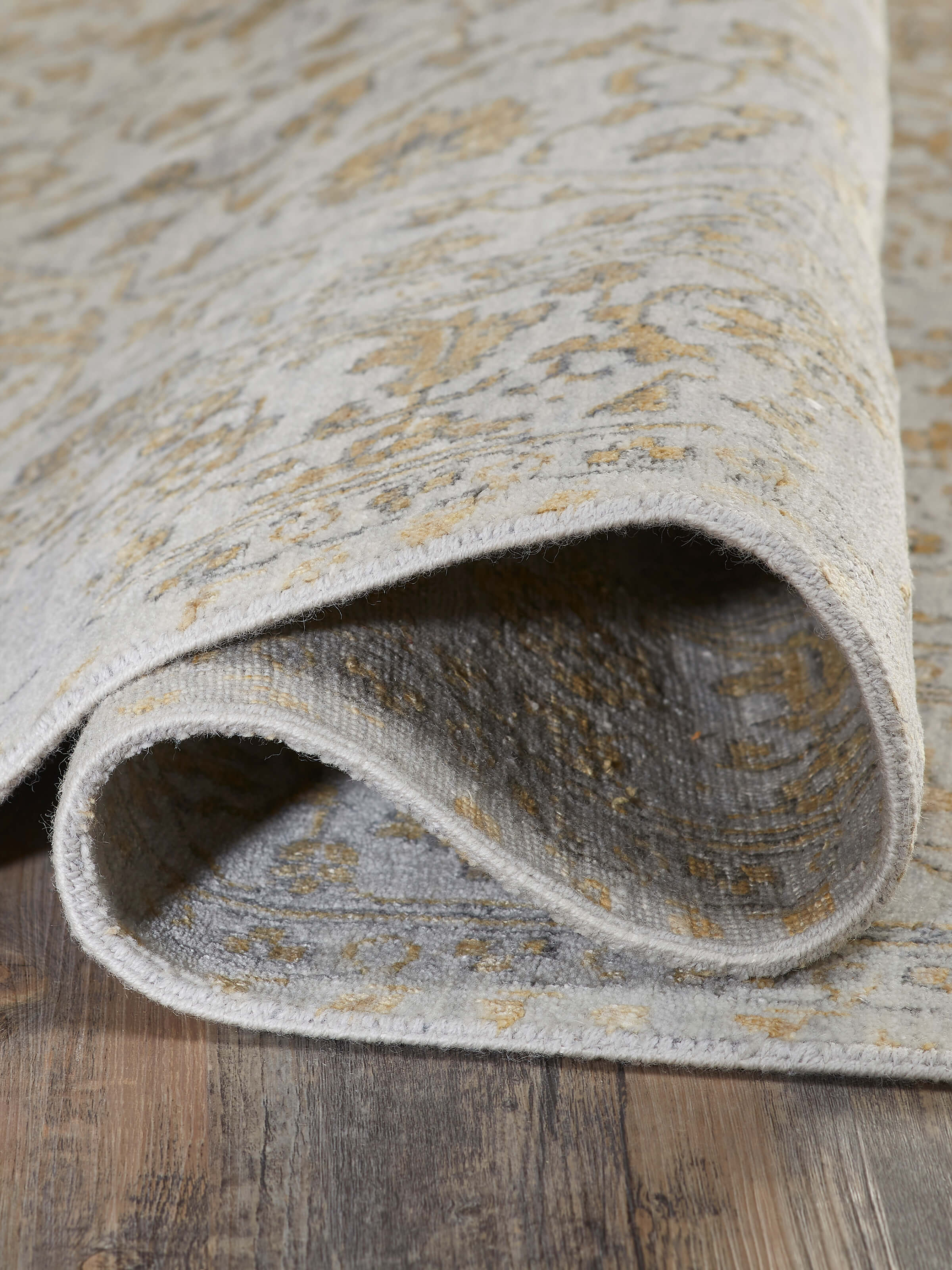 Top-down perspective of the distressed transitional grey Agra wool & viscose hand-knotted rug, featuring its design and borders