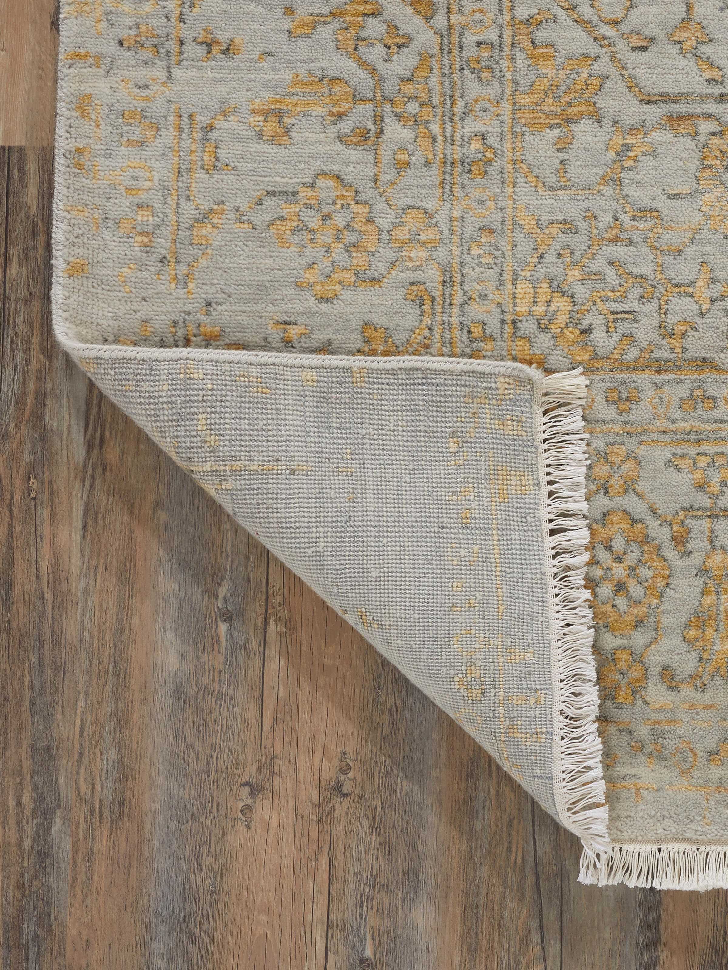 Angled view of the distressed transitional grey Agra wool & viscose hand-knotted rug, showcasing its distressing and finish