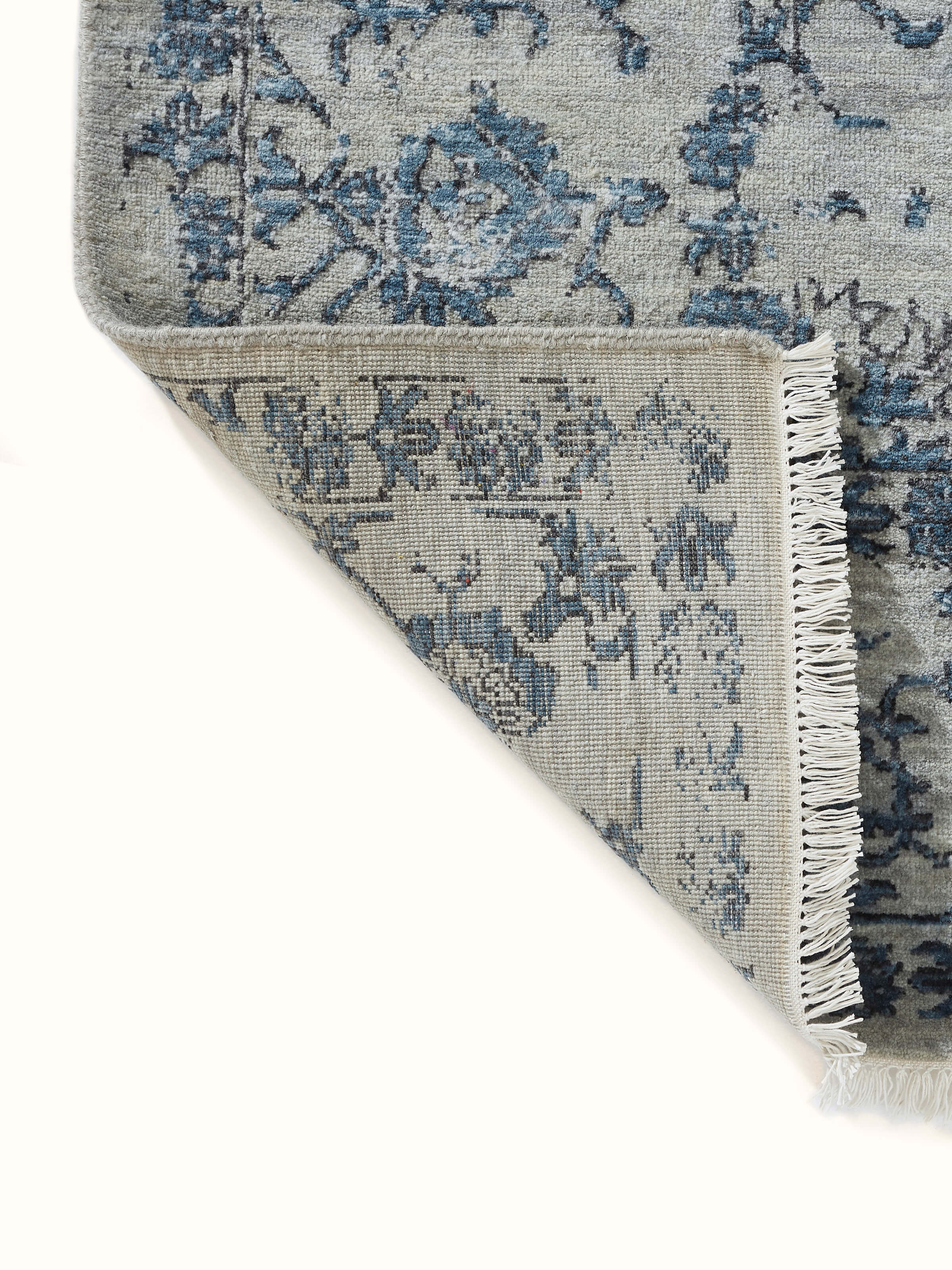 Bottom view highlighting the fine knotting and subtle blue accents in Swadesh’s Distressed Agra Wool Rug.