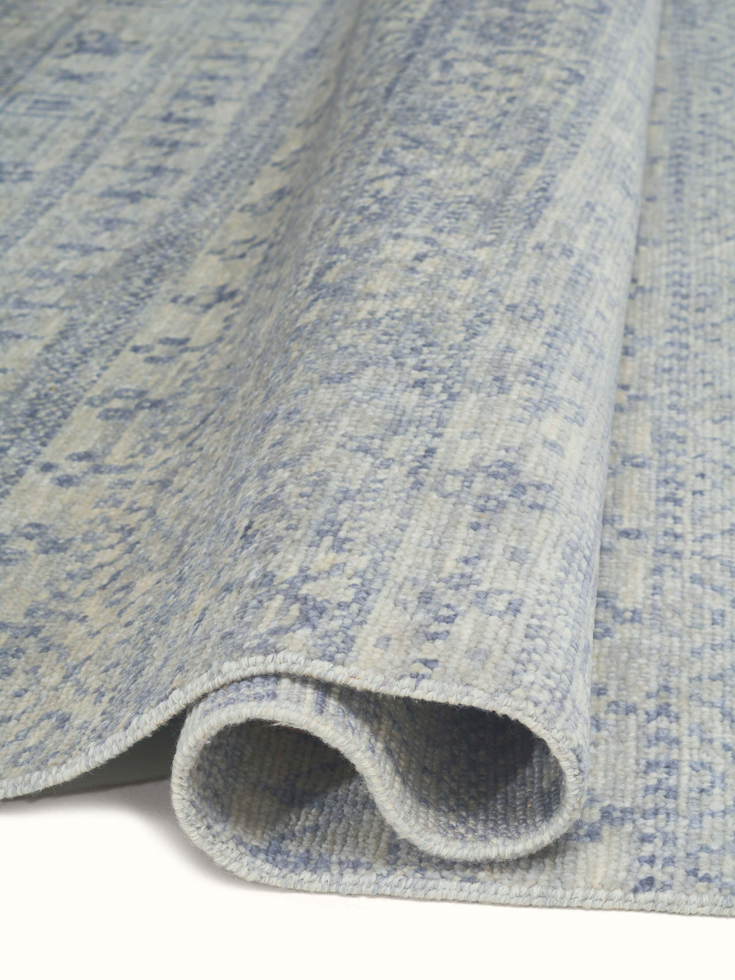 Detailed shot of the Bohemian Classic rug, showing the subtle variations in grey-blue tones and the quality of the wool material.
