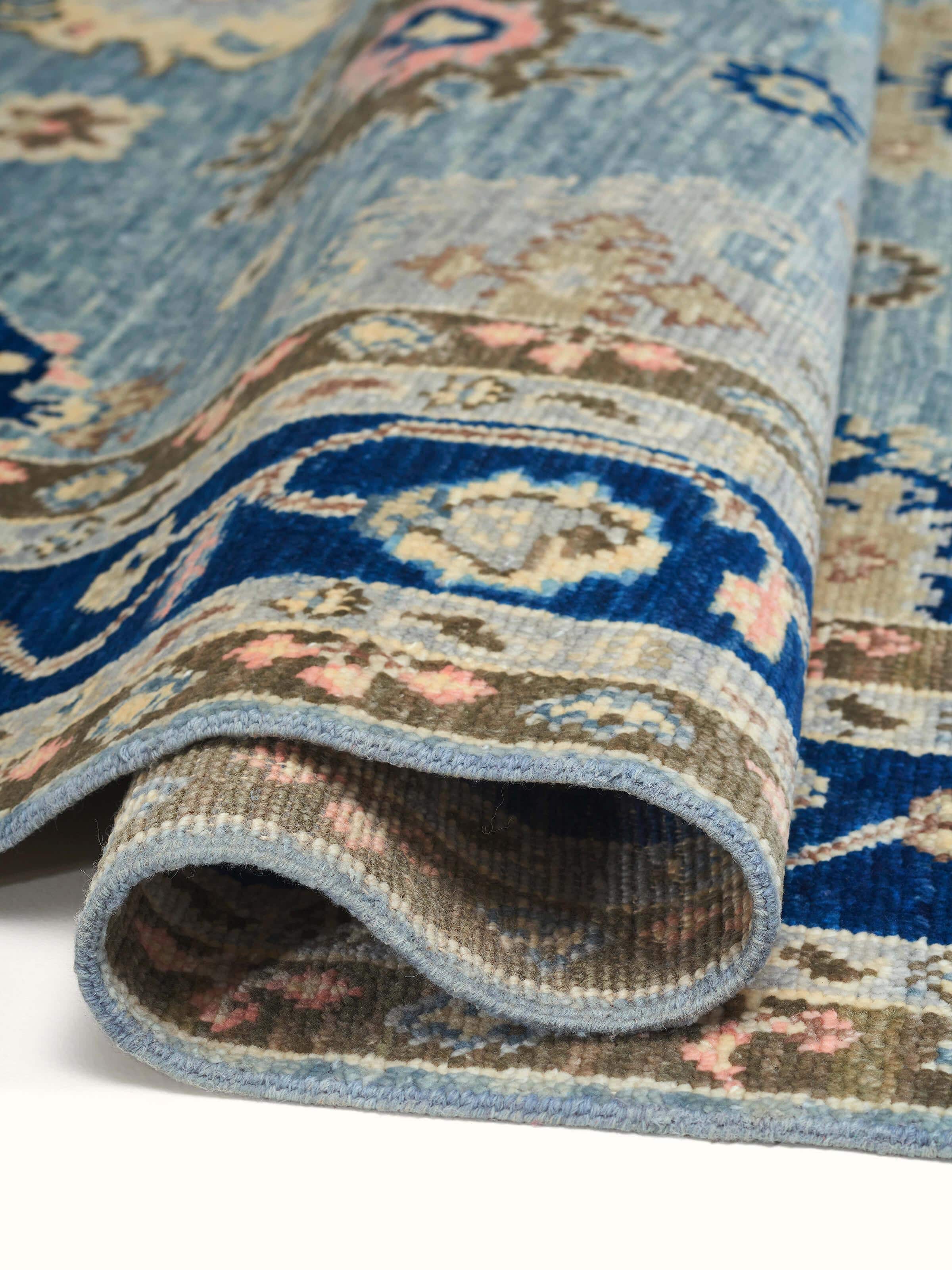Oushak traditional blue wool rug with a focus on the rug's borders and craftsmanship.