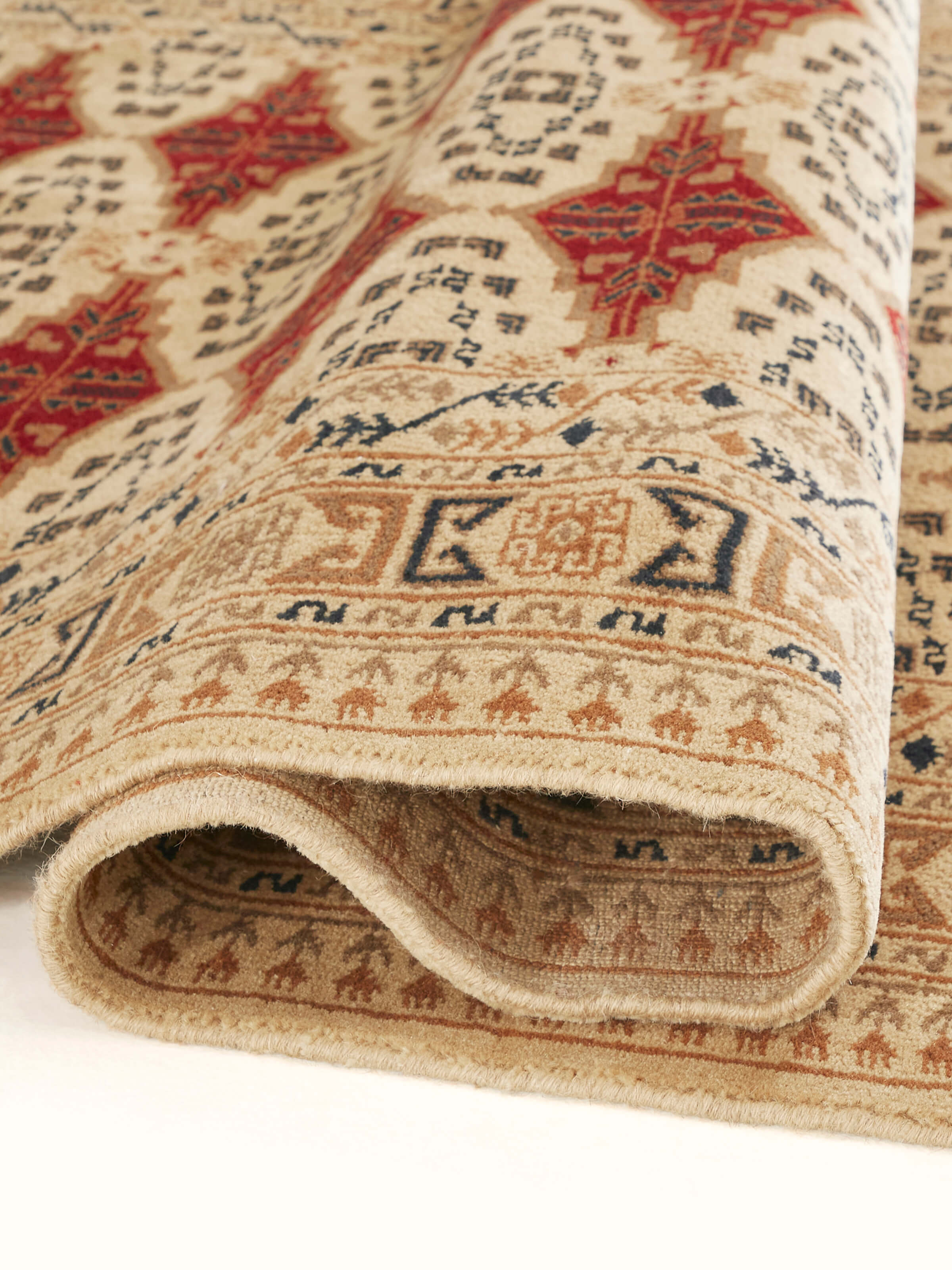 Close-up of Traditional Bukhara beige rust Gwalior wool hand-knotted rug's texture, emphasizing the wool fibers and pattern details