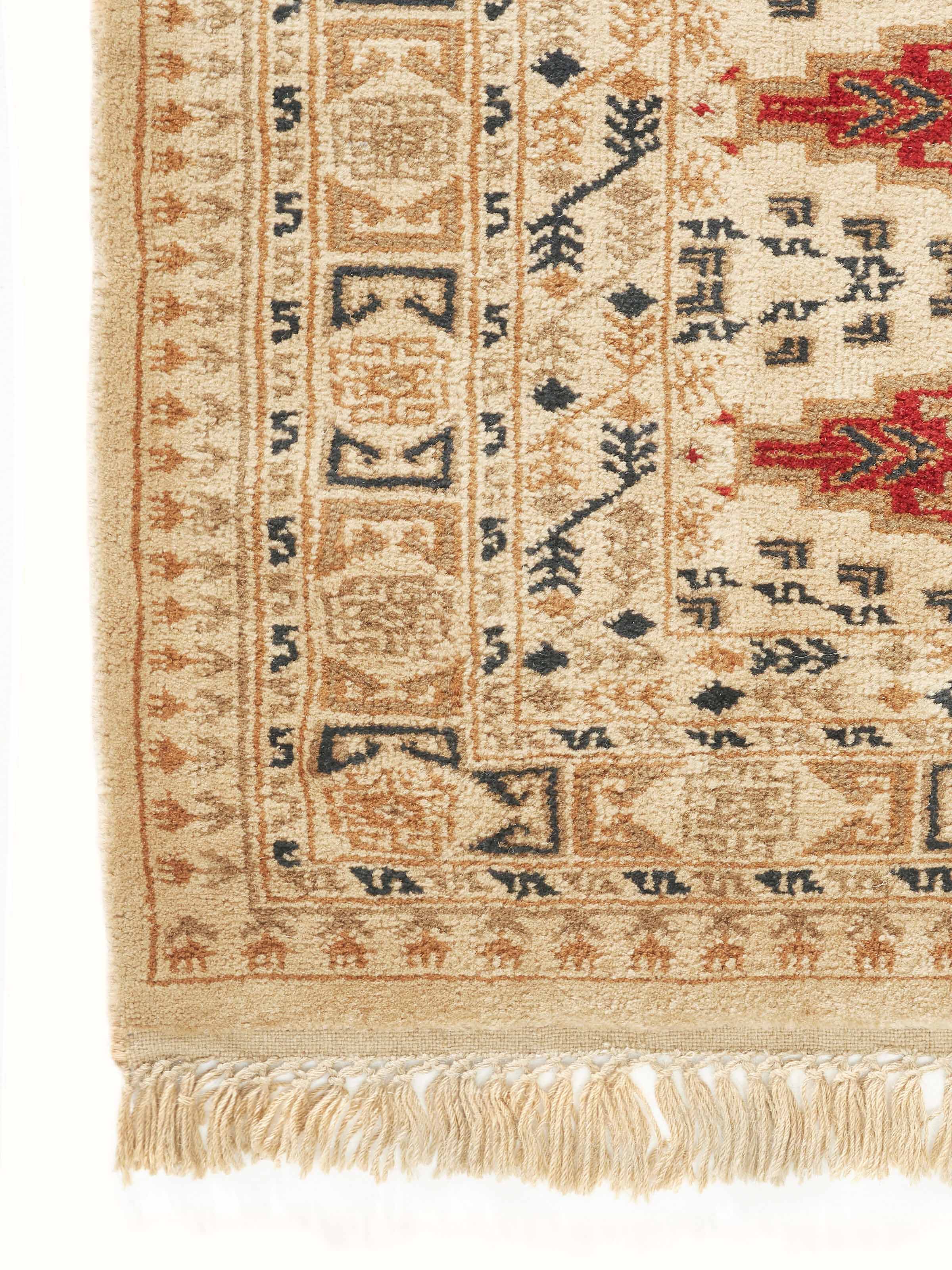 Traditional Bukhara beige rust Gwalior wool hand-knotted rug folded, showing its thickness and craftsmanship