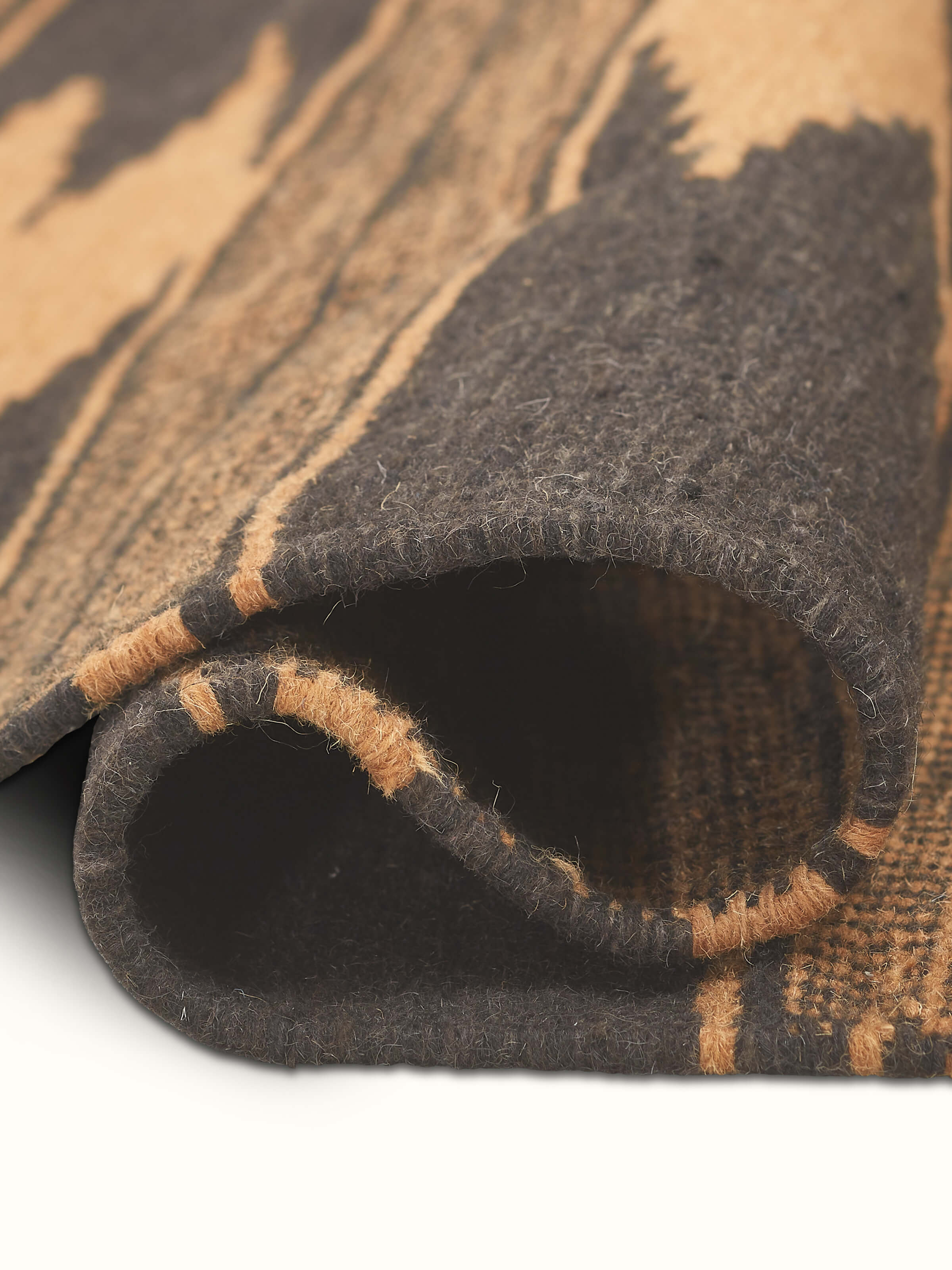 Artistic side view of Geo Diamonds dark brown Gujarat wool & cotton panja dhurrie kharad (3x5 ft)