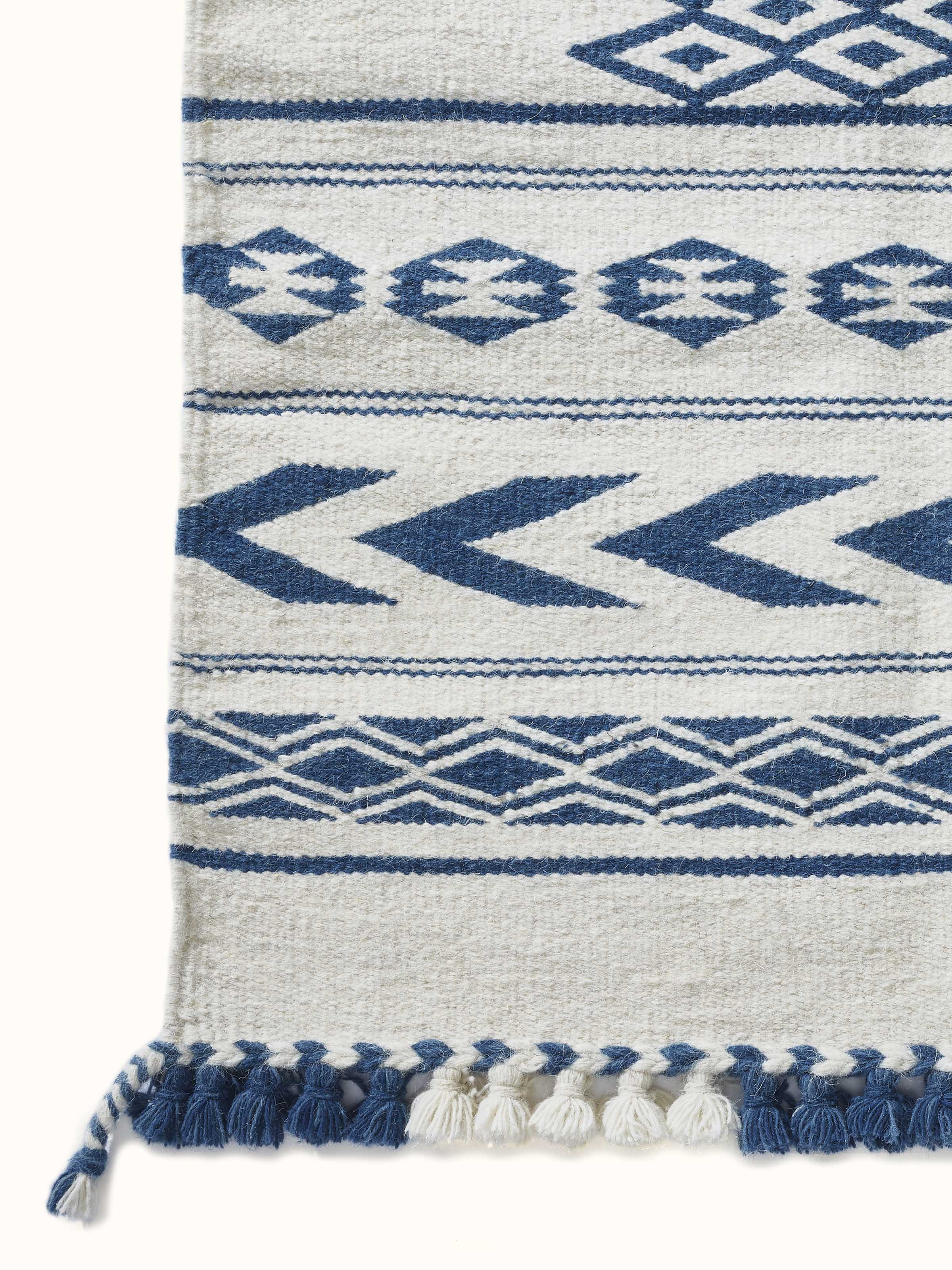 Side view of the Traditional Geo Ivory Indigo Gujarat Wool & Cotton Panja Dhurrie Kharad, emphasizing its texture and thickness.