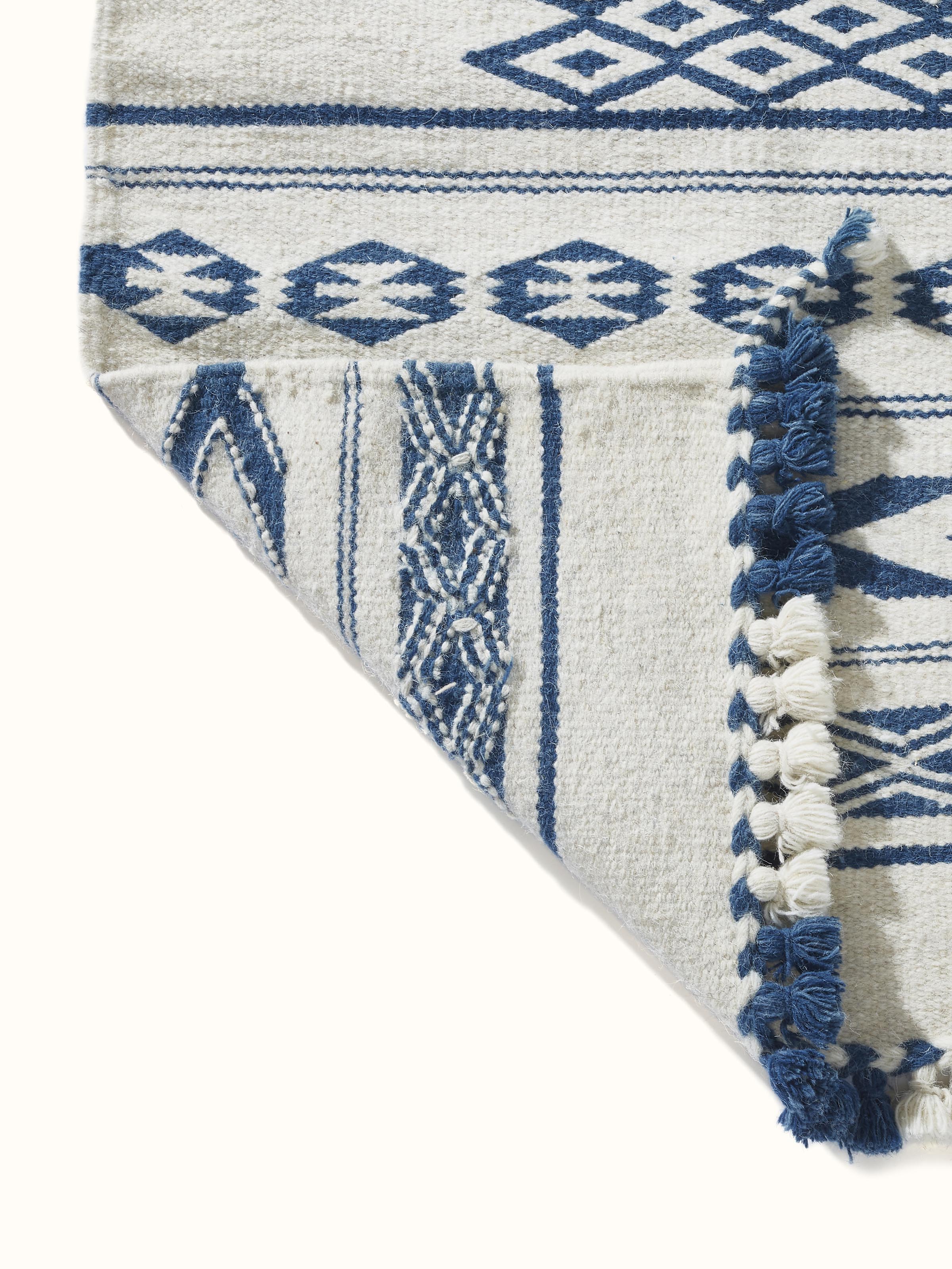 Traditional Geo Ivory Indigo Gujarat Wool & Cotton Panja Dhurrie Kharad in a room setting, showcasing its use as a decorative rug.