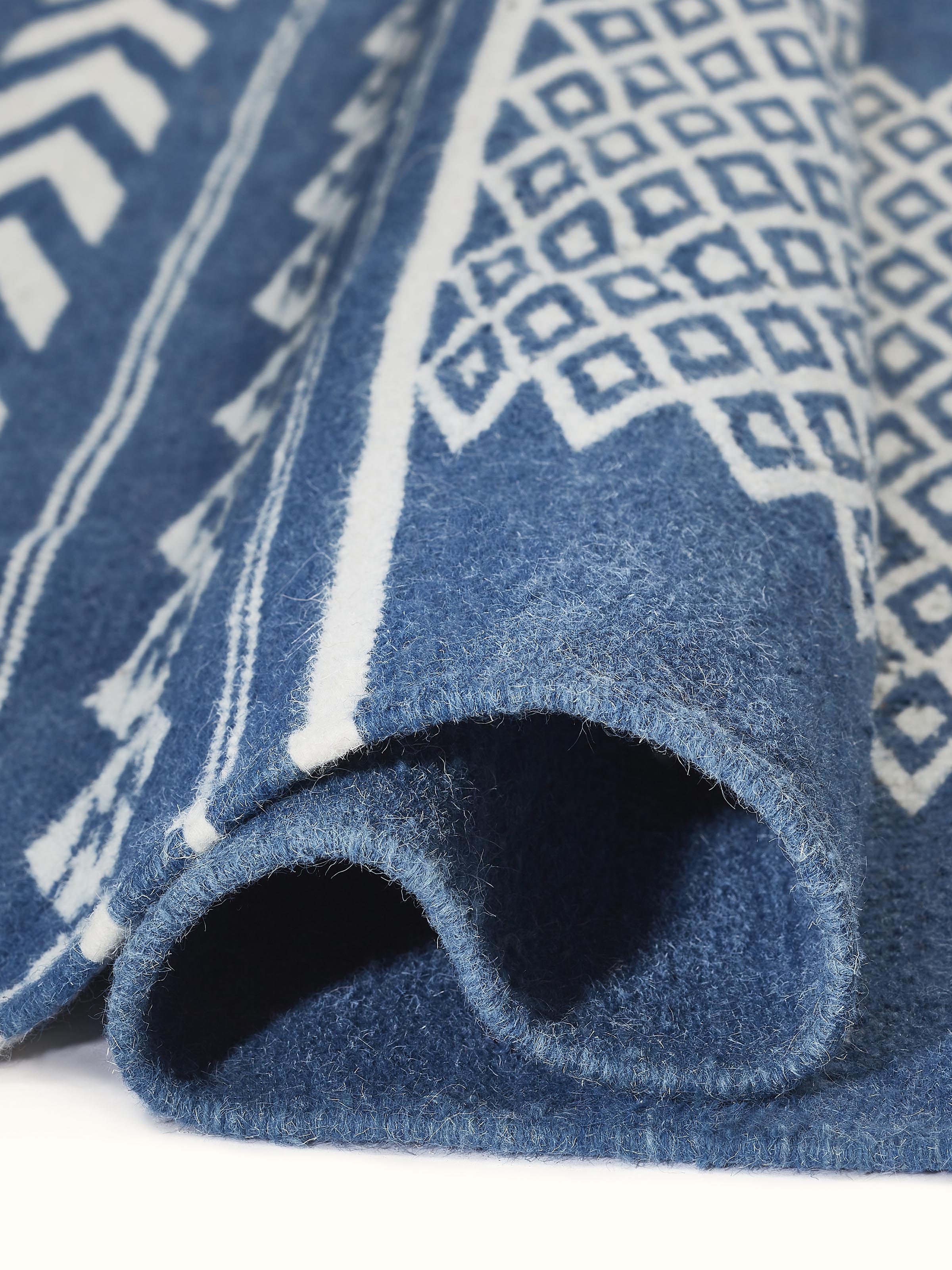 Traditional Geo Indigo Ivory Gujarat wool & cotton panja dhurrie kharad (4x6 ft) folded, showcasing the texture and design pattern.