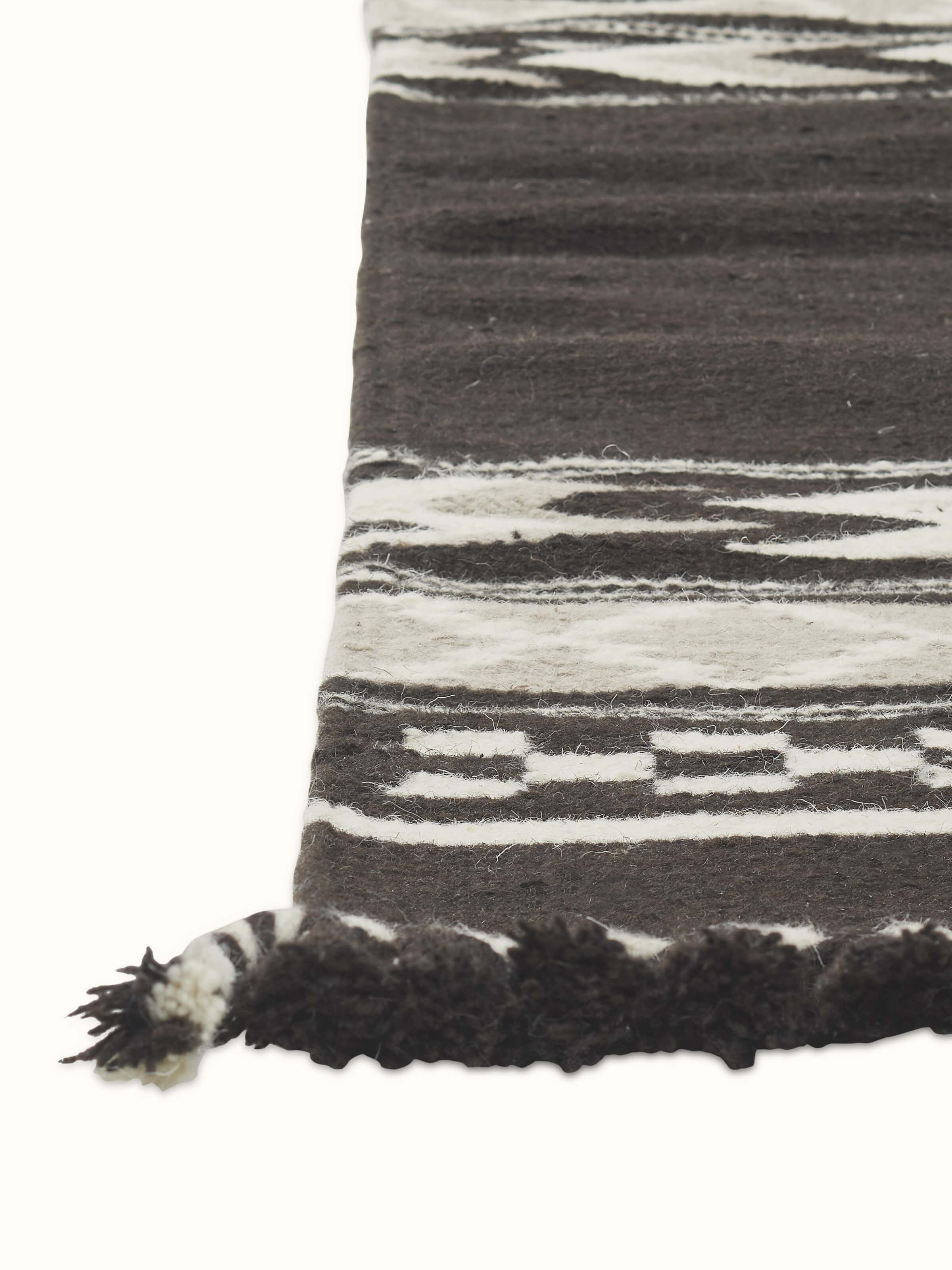 Detailed view of Geo border dark brown Gujarat wool & cotton panja dhurrie kharad (3x5 ft) focusing on the geometric patterns and material quality