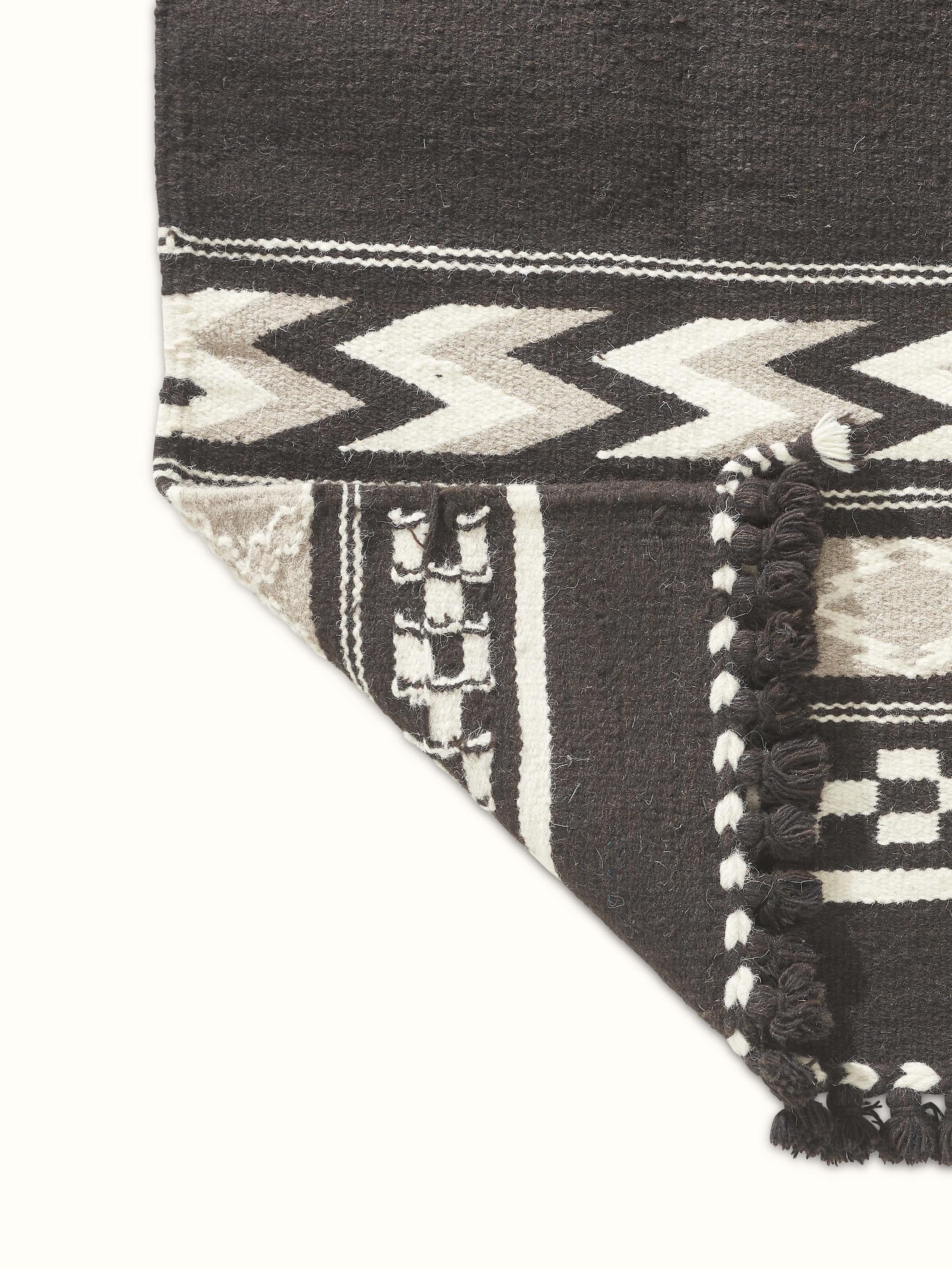 Detailed view of Geo border dark brown Gujarat wool & cotton panja dhurrie kharad (3x5 ft) emphasizing the wool and cotton blend and border design
