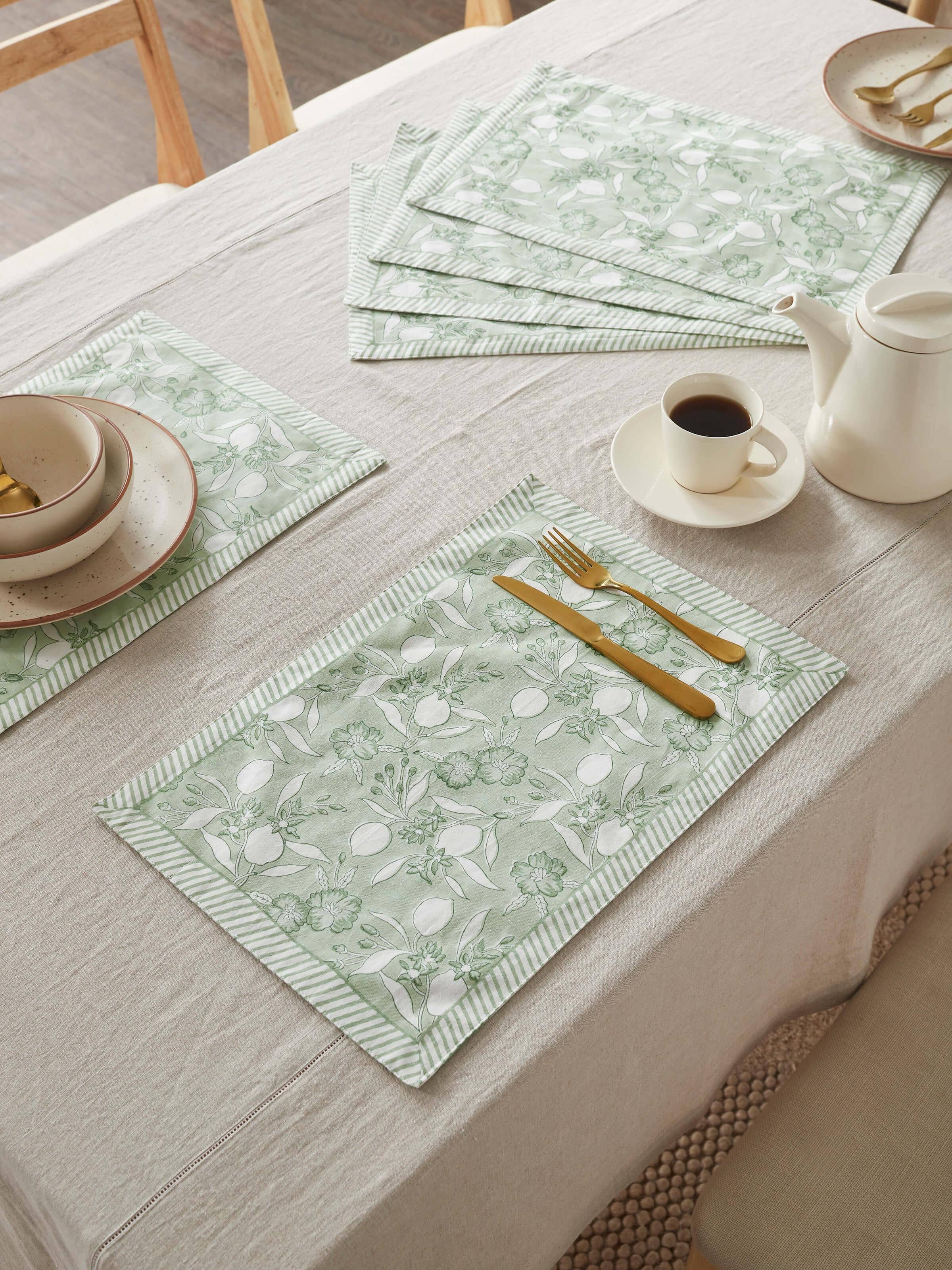 Table setup with Anika green floral mats enhancing traditional dining decor.