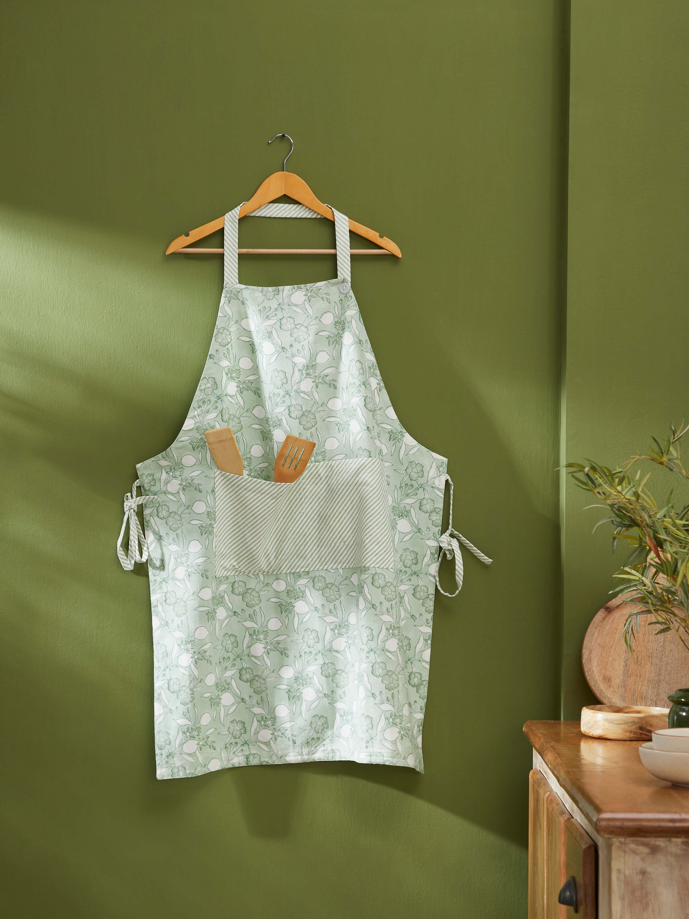 Detailed view of green floral cotton Sanganeri block printed apron highlighting the block print design and fabric texture.