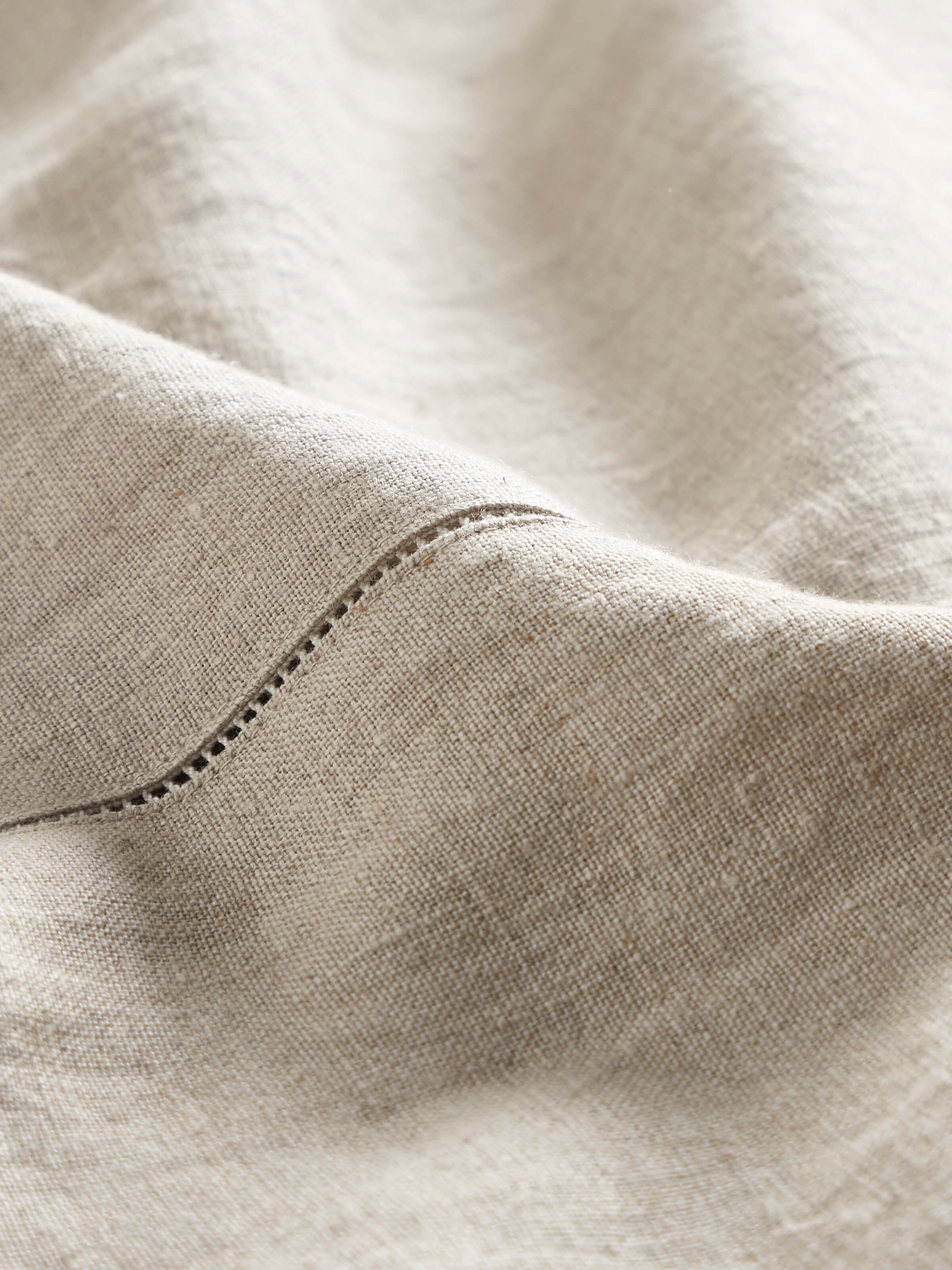 Angled view of Mughal Beige Floral Linen Kashmir Chain Stitch Embroidered Table Cover on a dining table, highlighting the elegant design.
