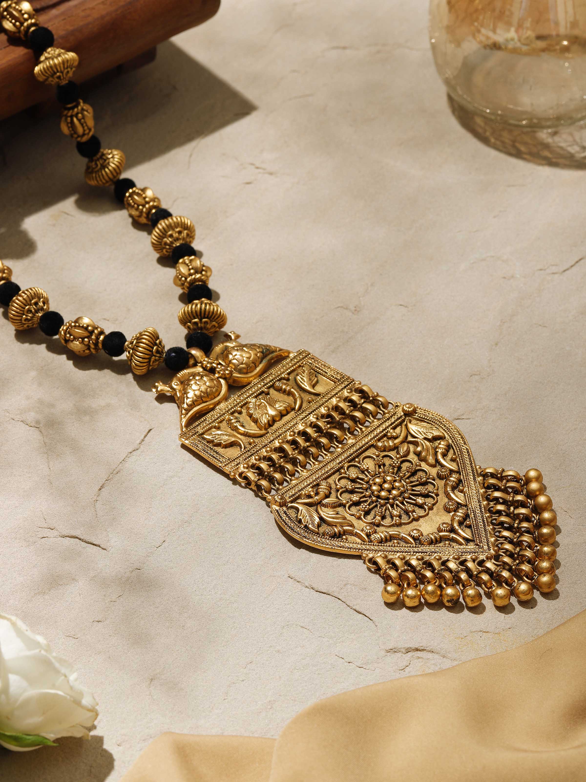 Side view of silversmithing long necklace emphasizing elegant design.