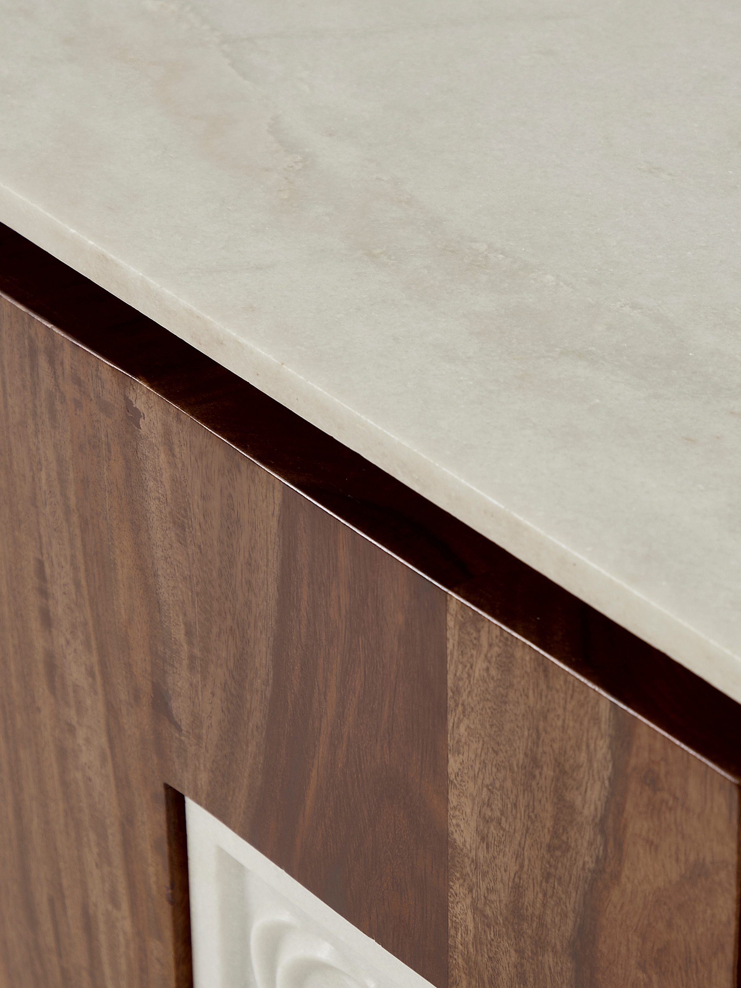 View of the sideboard’s detailed carvings and marble top from an angle, emphasizing the craftsmanship and design.