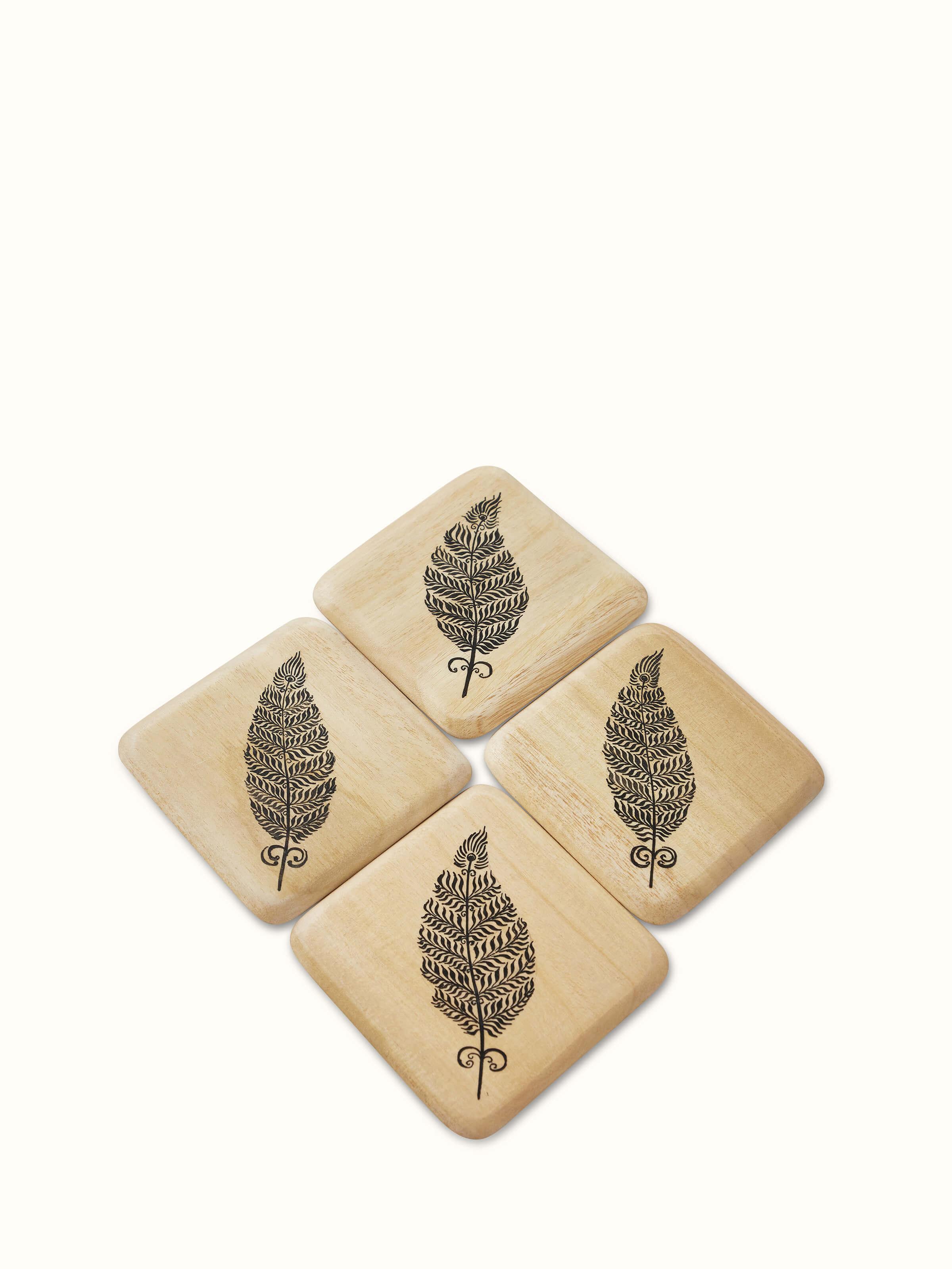 Set of Carved Gamhar Wood Coasters (Black) displaying intricate designs.