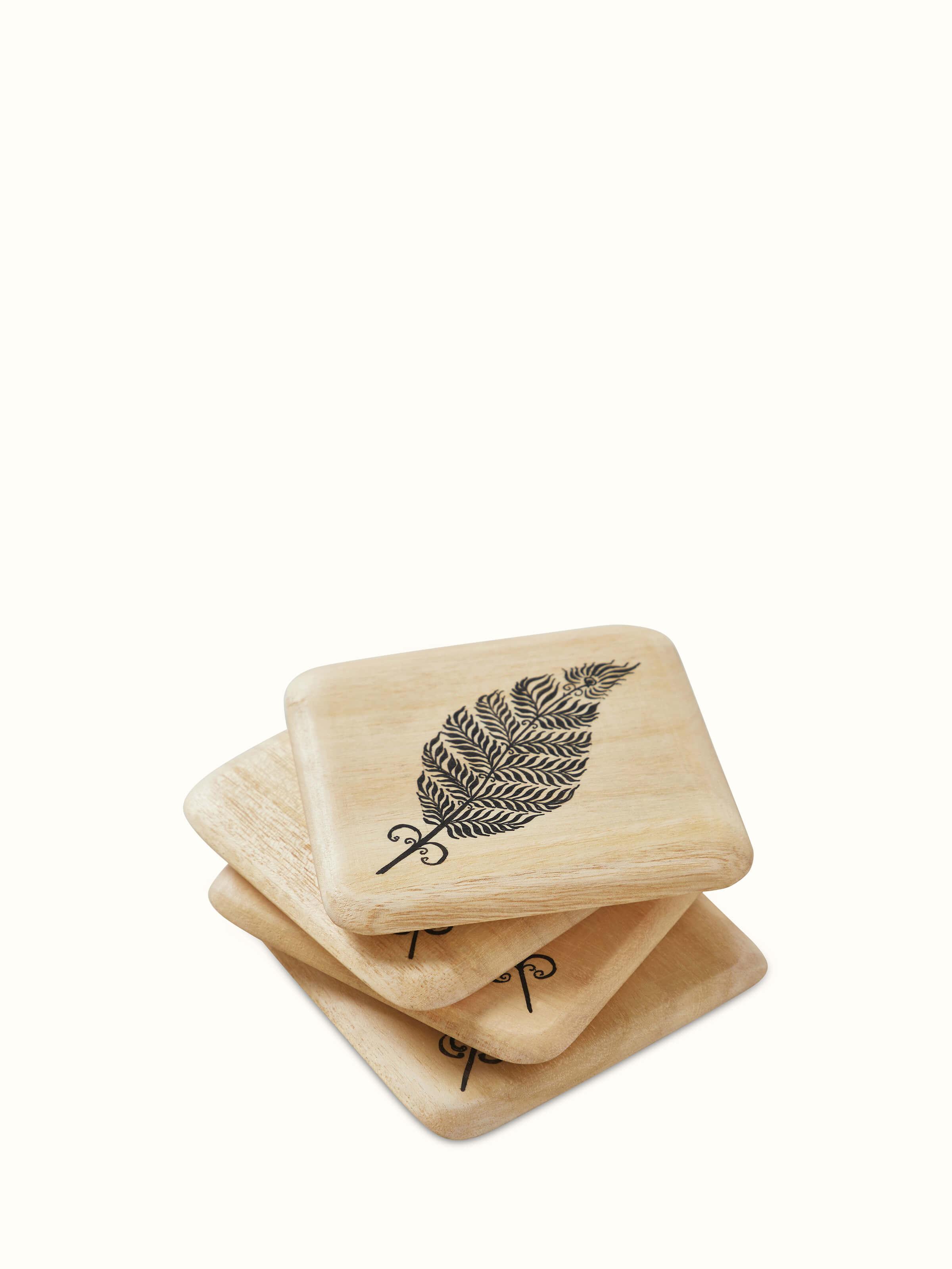 Carved Gamhar Wood Coasters (Black) arranged to show their design and texture.