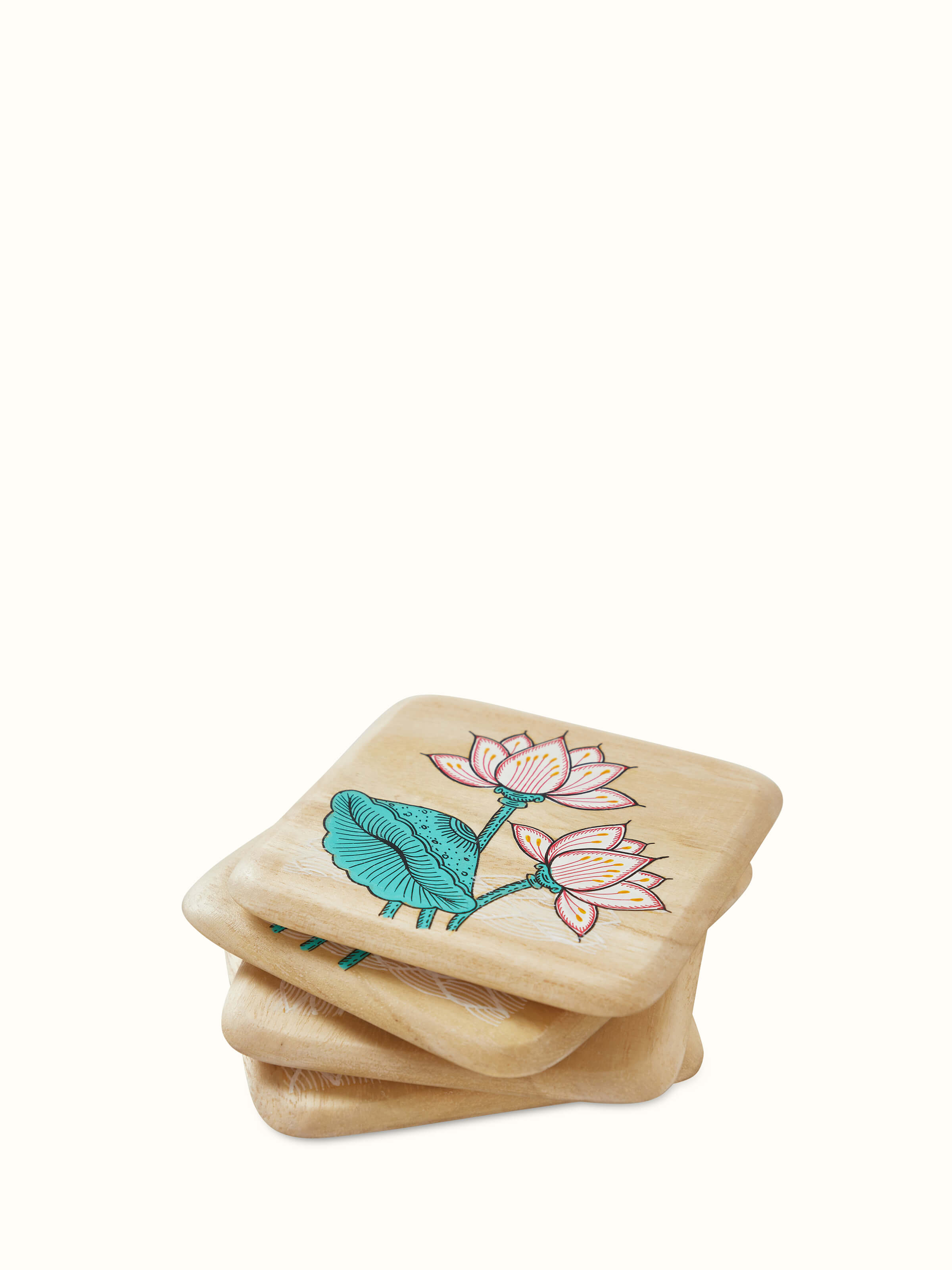 Another view of the carved gamhar wood coasters in white and teal, focusing on their unique patterns.