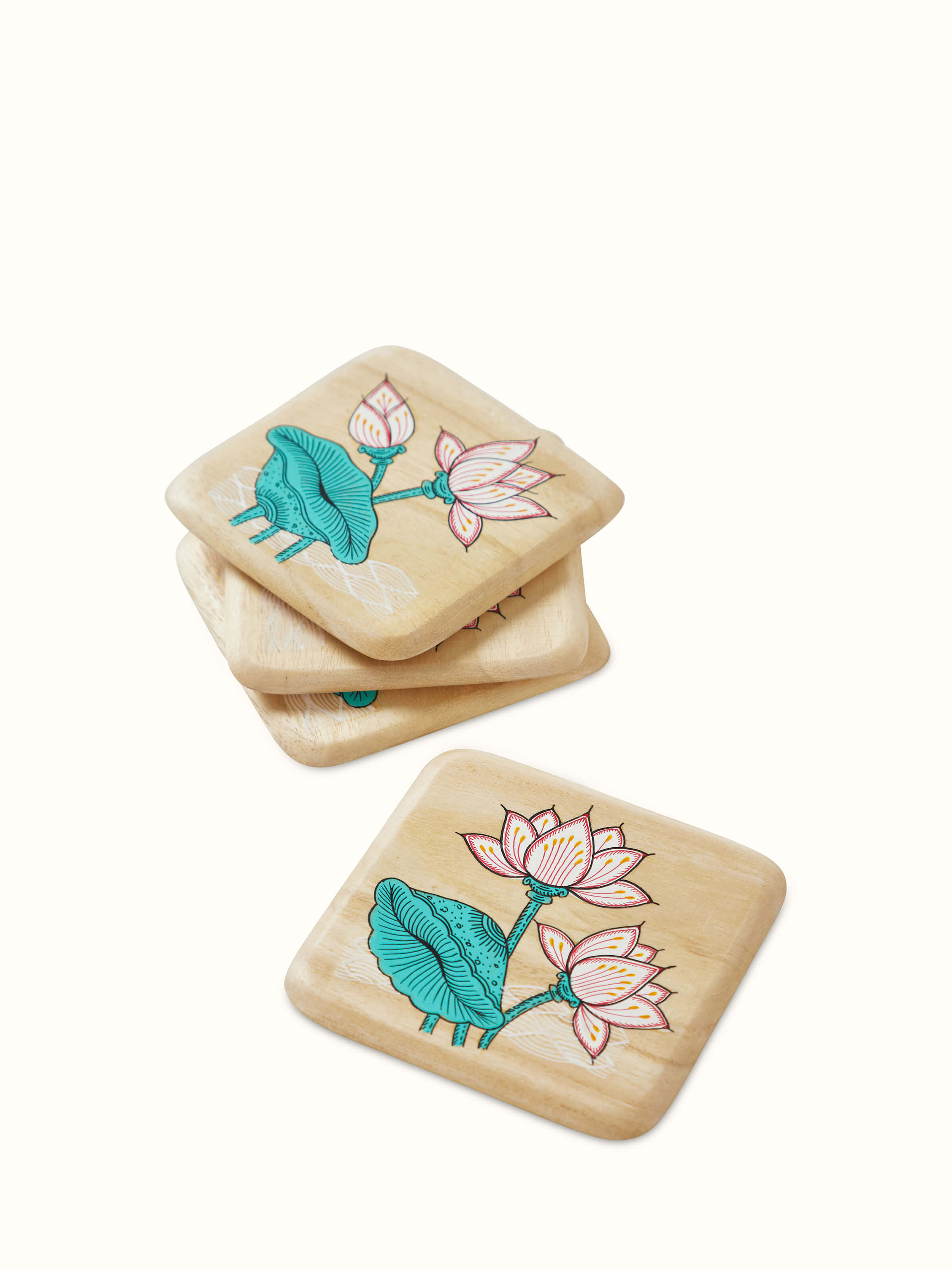 Full set of four carved gamhar wood coasters in white and teal, arranged to display their elegant design.