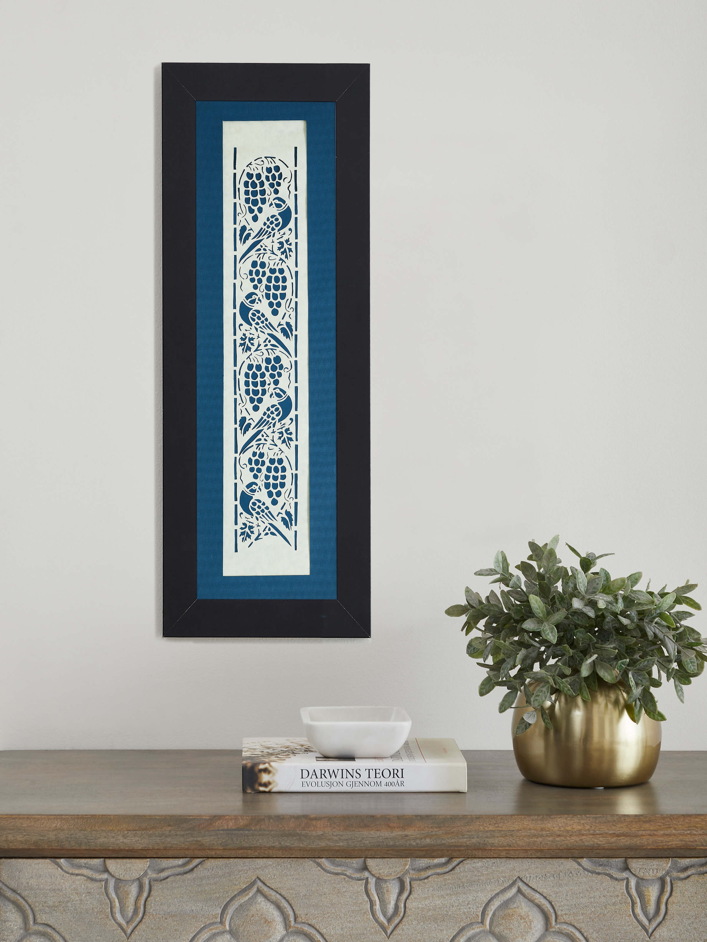 Close-up of Sanjhi paper stencil parrot wall art, highlighting the intricate stencil work and vivid colors.