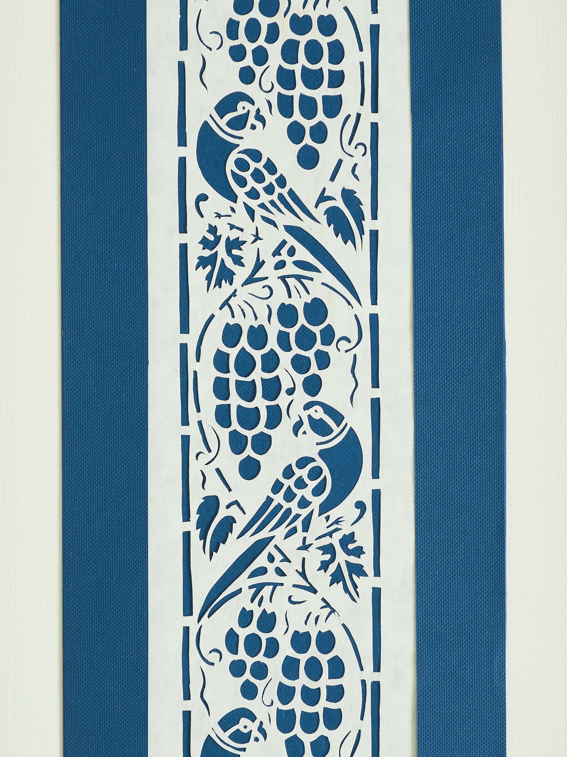 Angled view of Sanjhi paper stencil parrot wall art, focusing on the vibrant colors and detailed pattern.