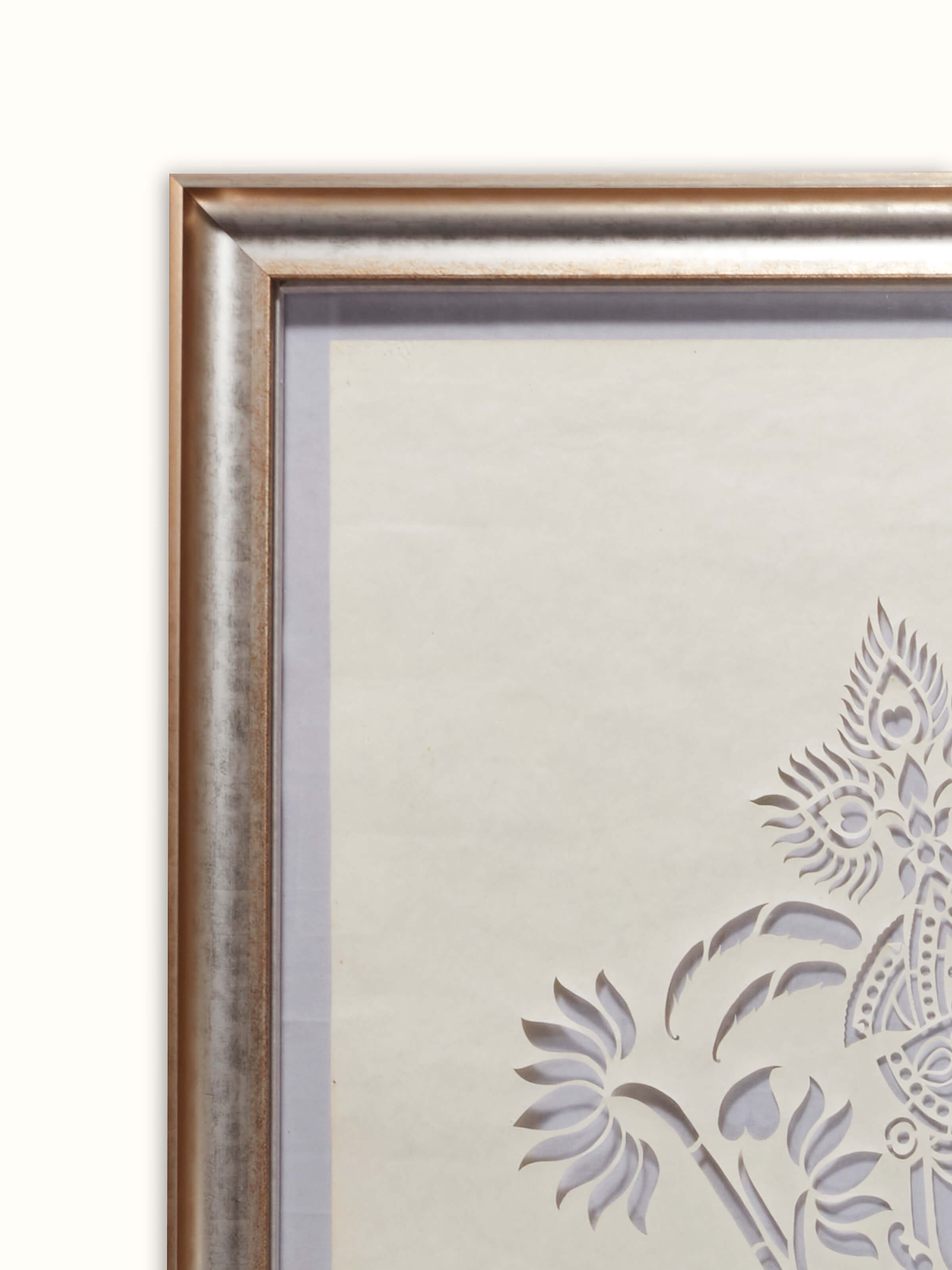 Close-up of Sanjhi paper stencil wall art focusing on the delicate paper cut-out work and artistic details