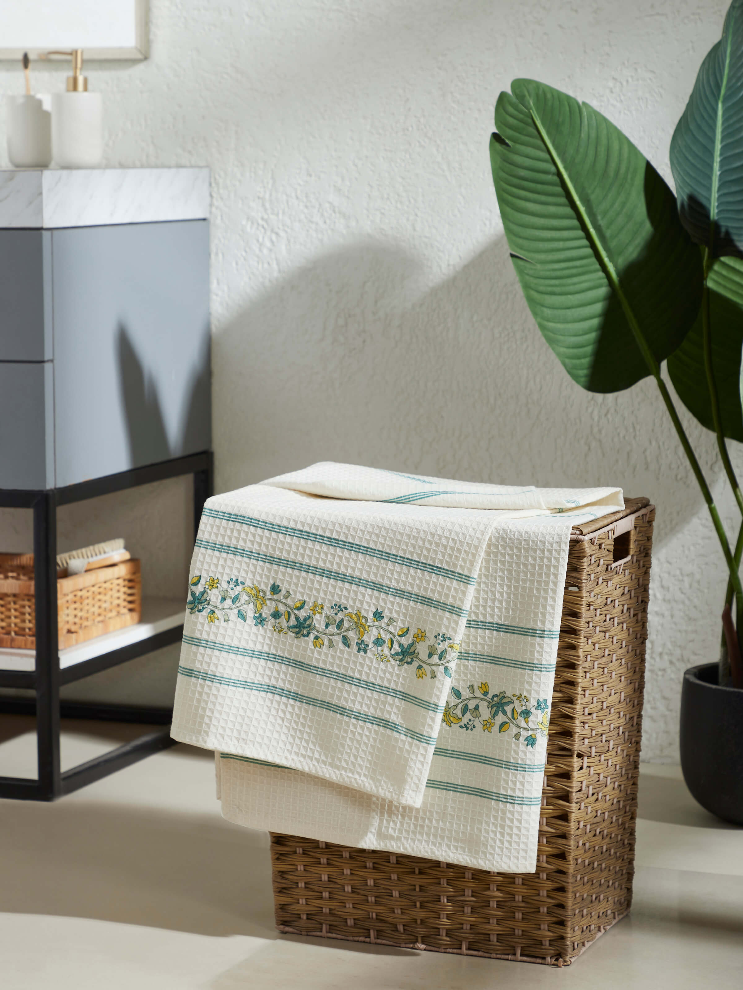 Side view of Palampore stripe yellow floral cotton Sanganeri block printed bath towel (L) highlighting its design and texture.