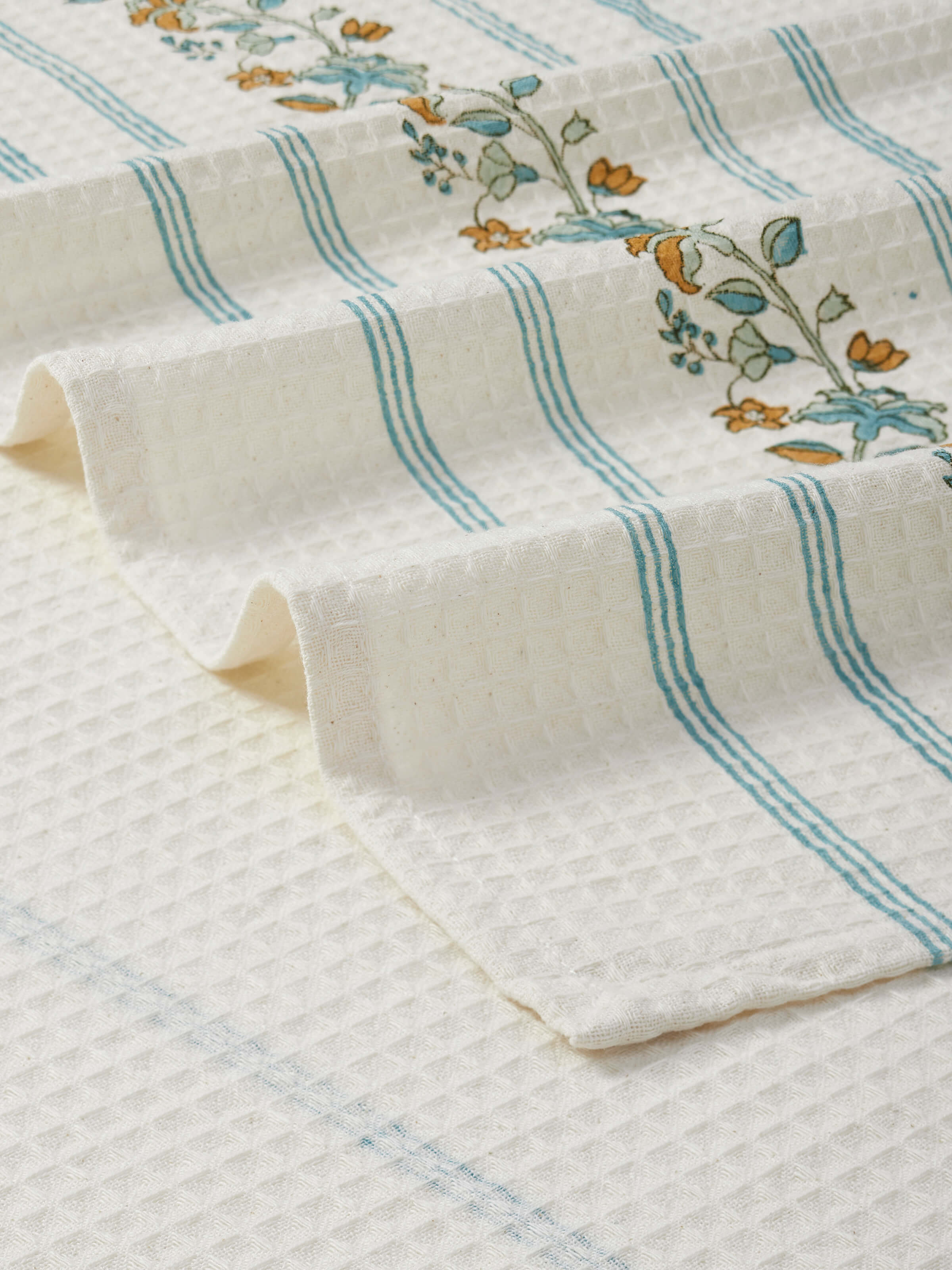 Full view of Palampore stripe white floral cotton Sanganeri block printed bath towel on a towel rack.