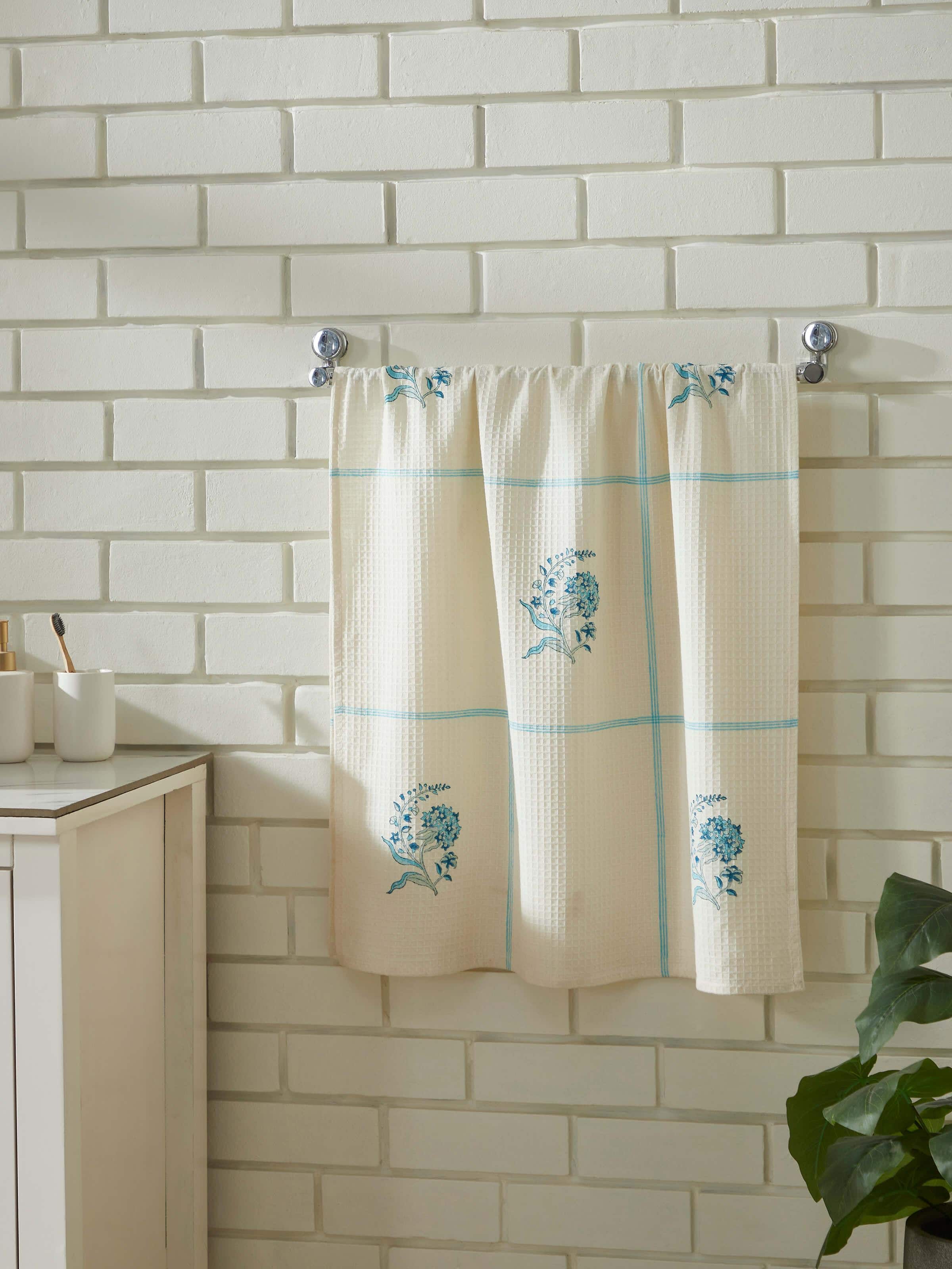 Close-up of Palampore Buta blue floral cotton Sanganeri block printed bath towel (L) highlighting the detailed block print and fabric texture.