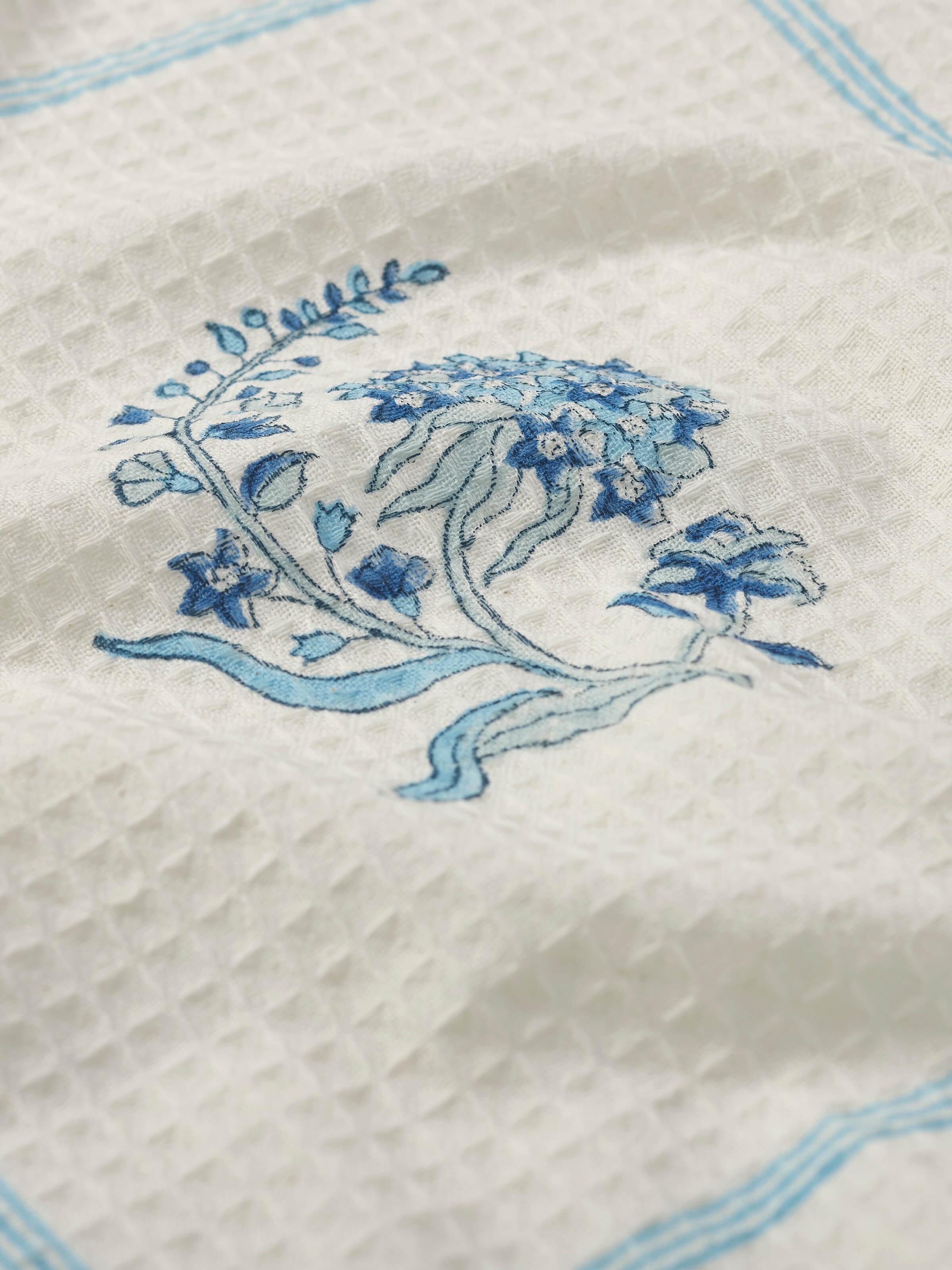 Detailed view of Palampore Buta blue floral cotton Sanganeri block printed bath towel (L) focusing on the floral block print and cotton softness.