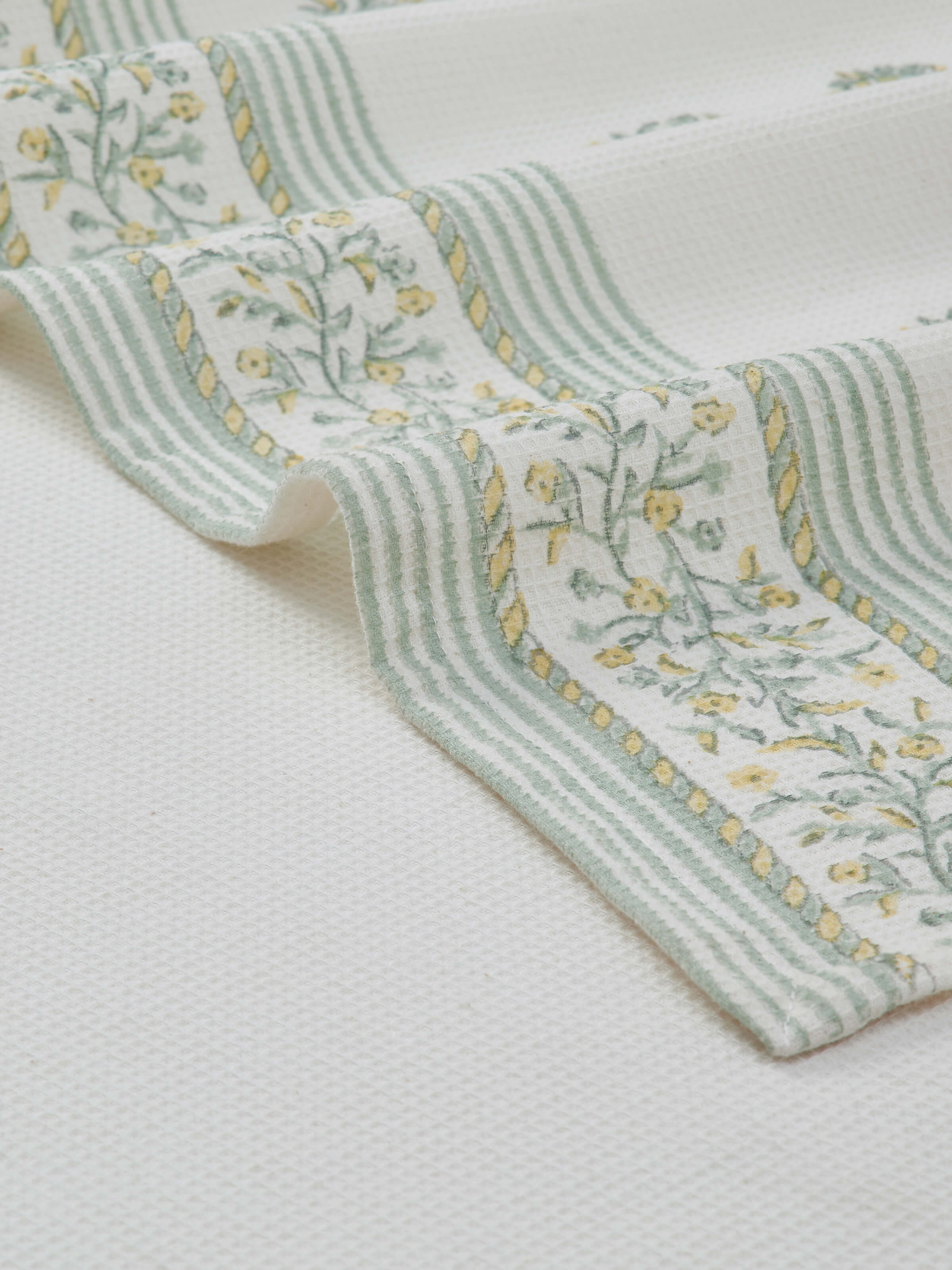 Ambi border yellow floral cotton Sanganeri block printed bath towel (XL) folded, emphasizing the intricate block print.