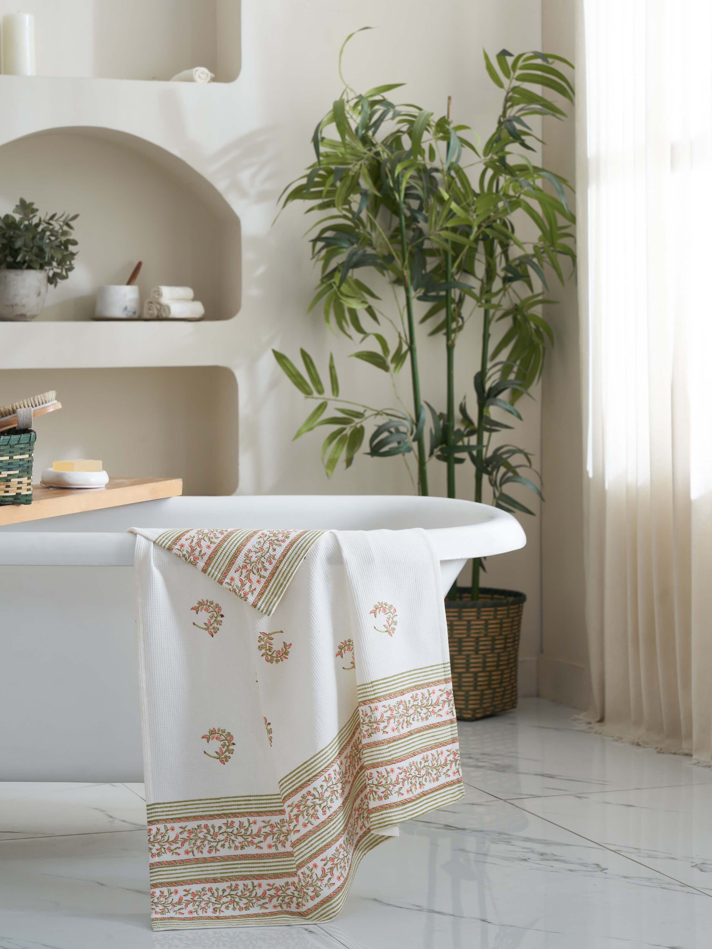 Side view of Ambi allover peach floral cotton Sanganeri block printed bath towel (L), highlighting the design and texture.