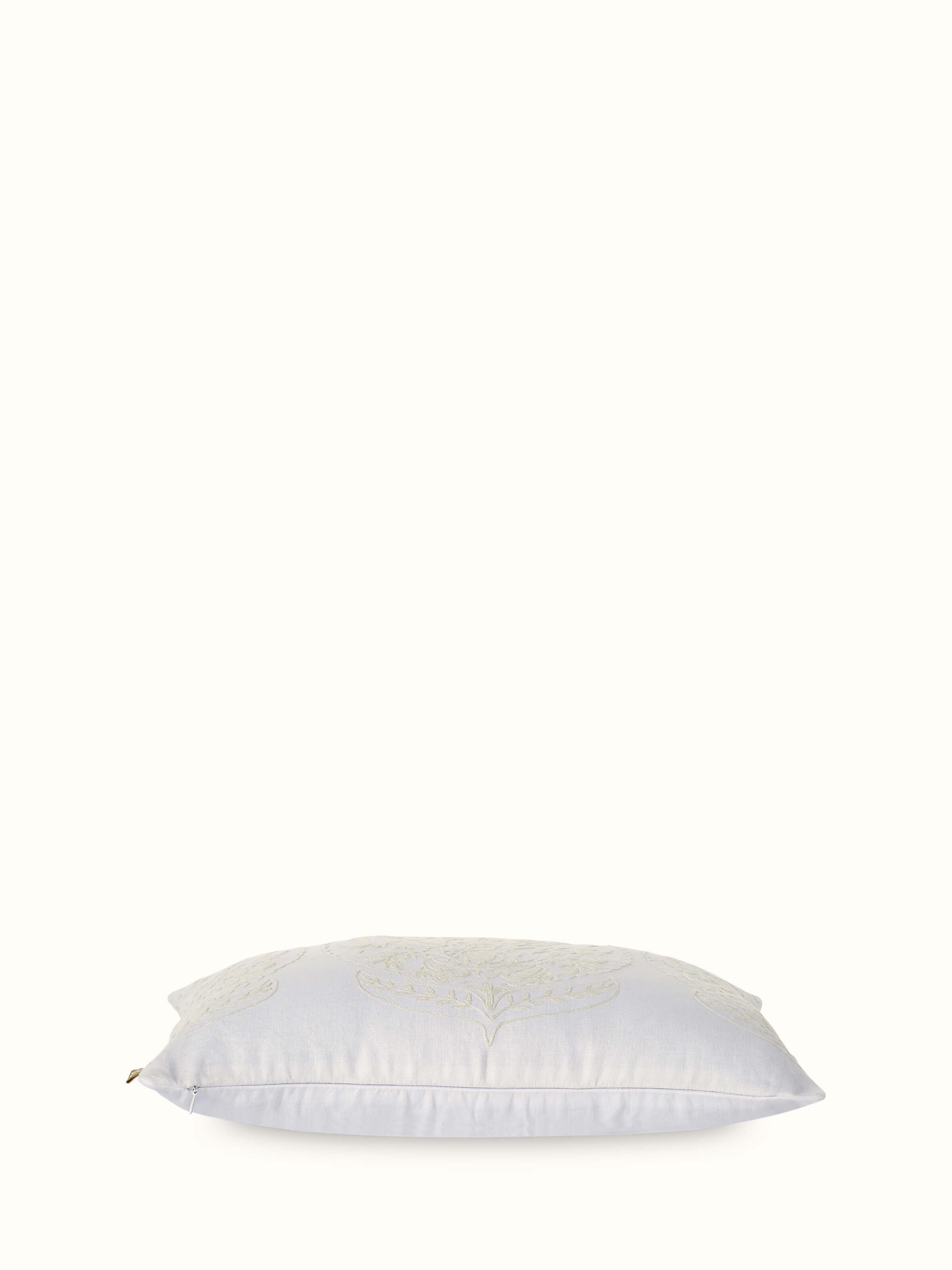 Angled view of Razza ivory carnation allover linen crewel hand-embroidered cushion cover, showing the texture and design of the embroidery