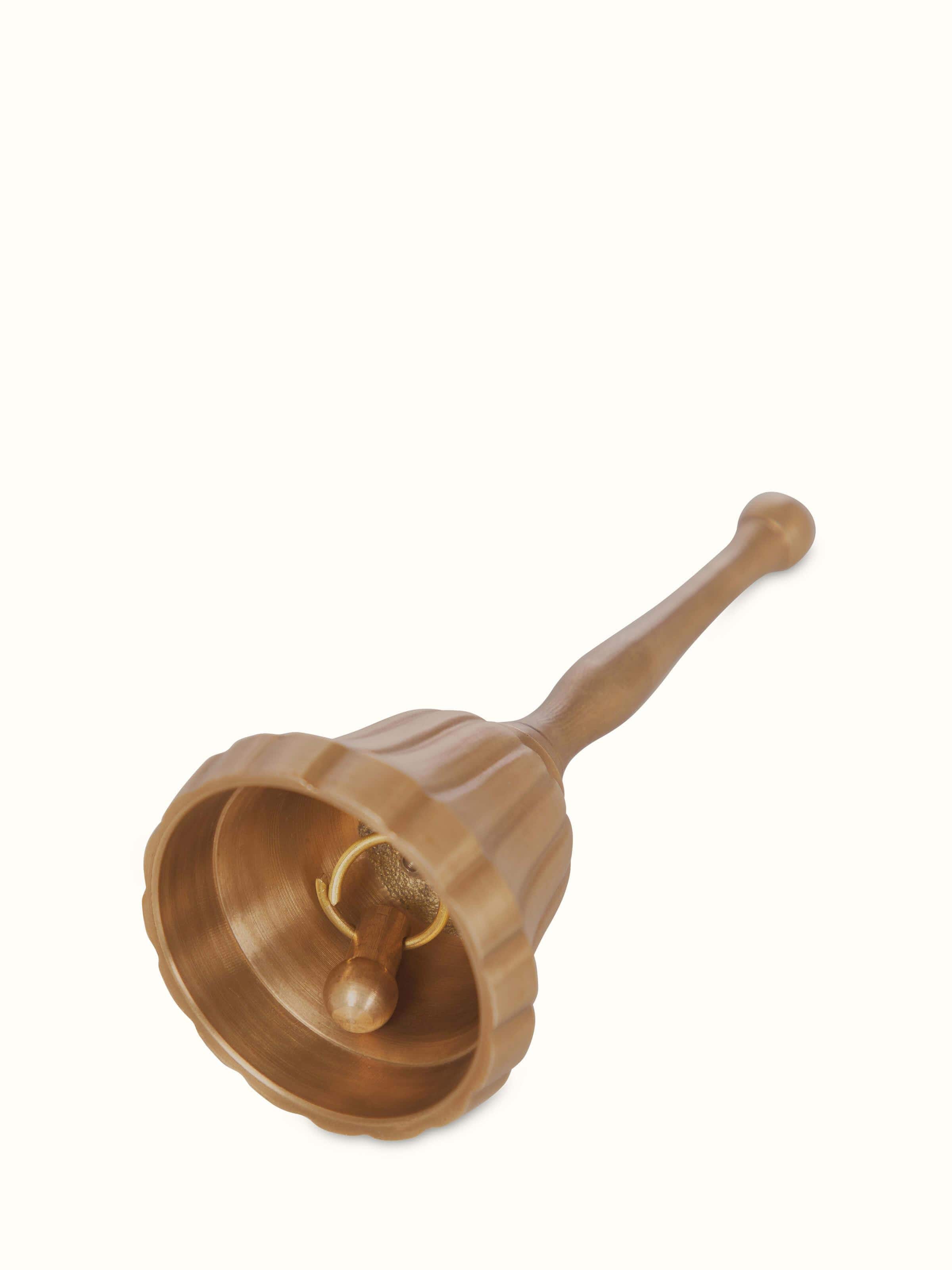 Angled view of polished brass curved pooja bell, highlighting its design