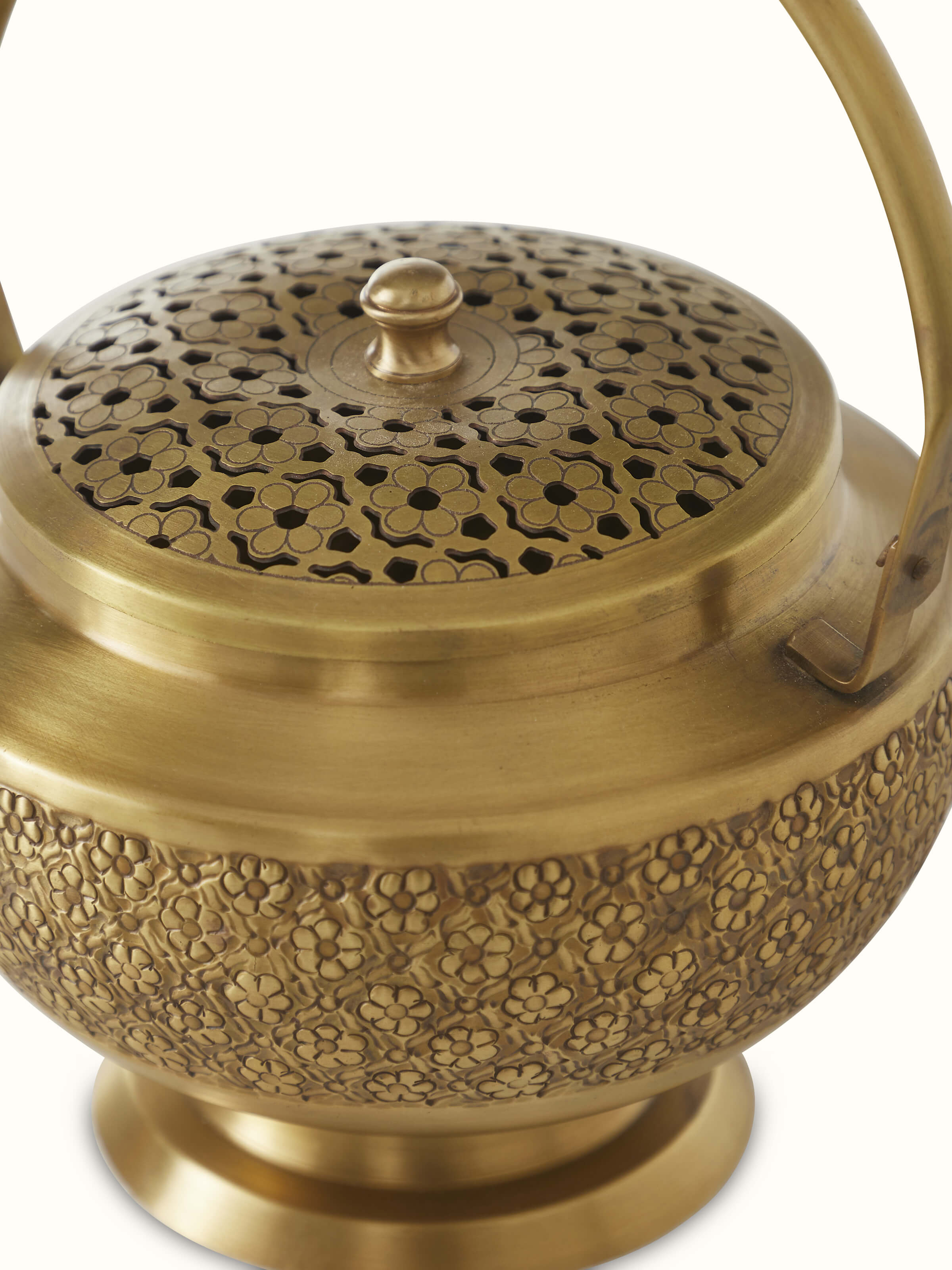 Close-up of traditional polished brass dhuna with detailed engravings