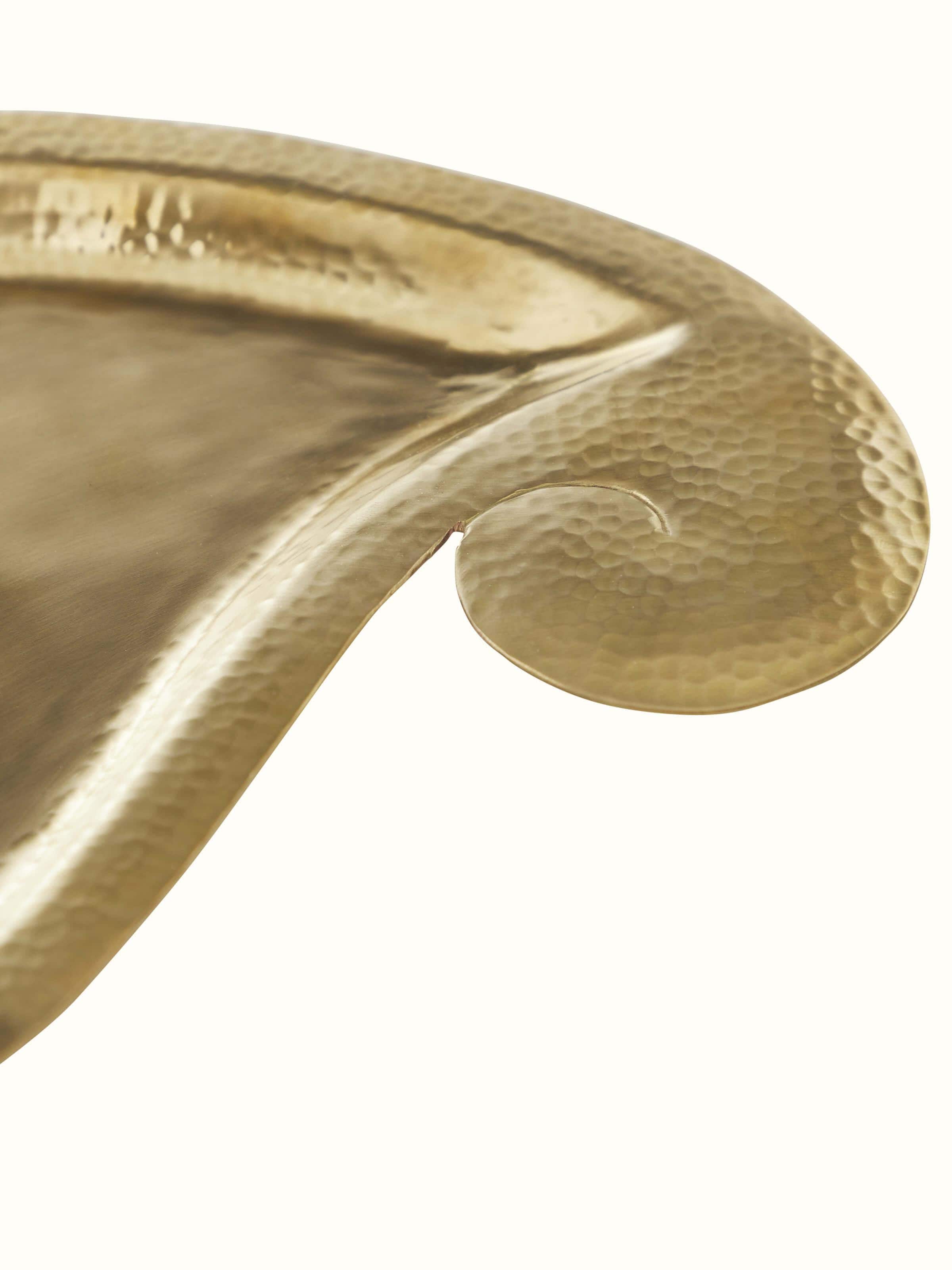 Close-up view of Polished brass paisley pooja thali focusing on the intricate brasswork and refined texture.