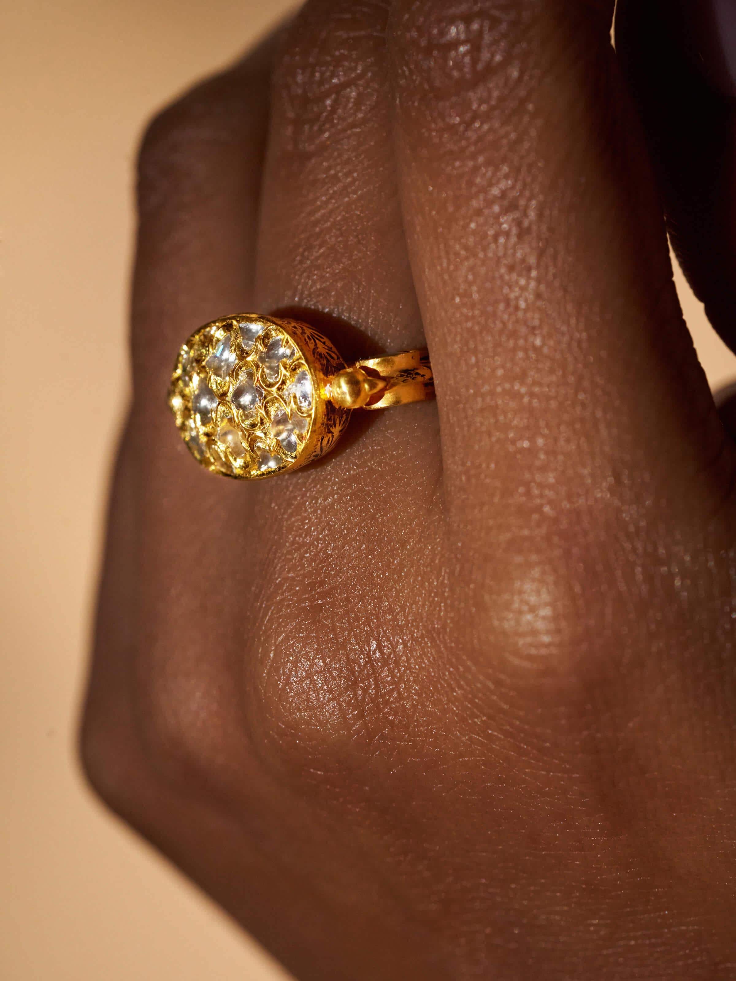 Detail image of Badroom 22 Karat gold ring focusing on carved motifs and gold texture.