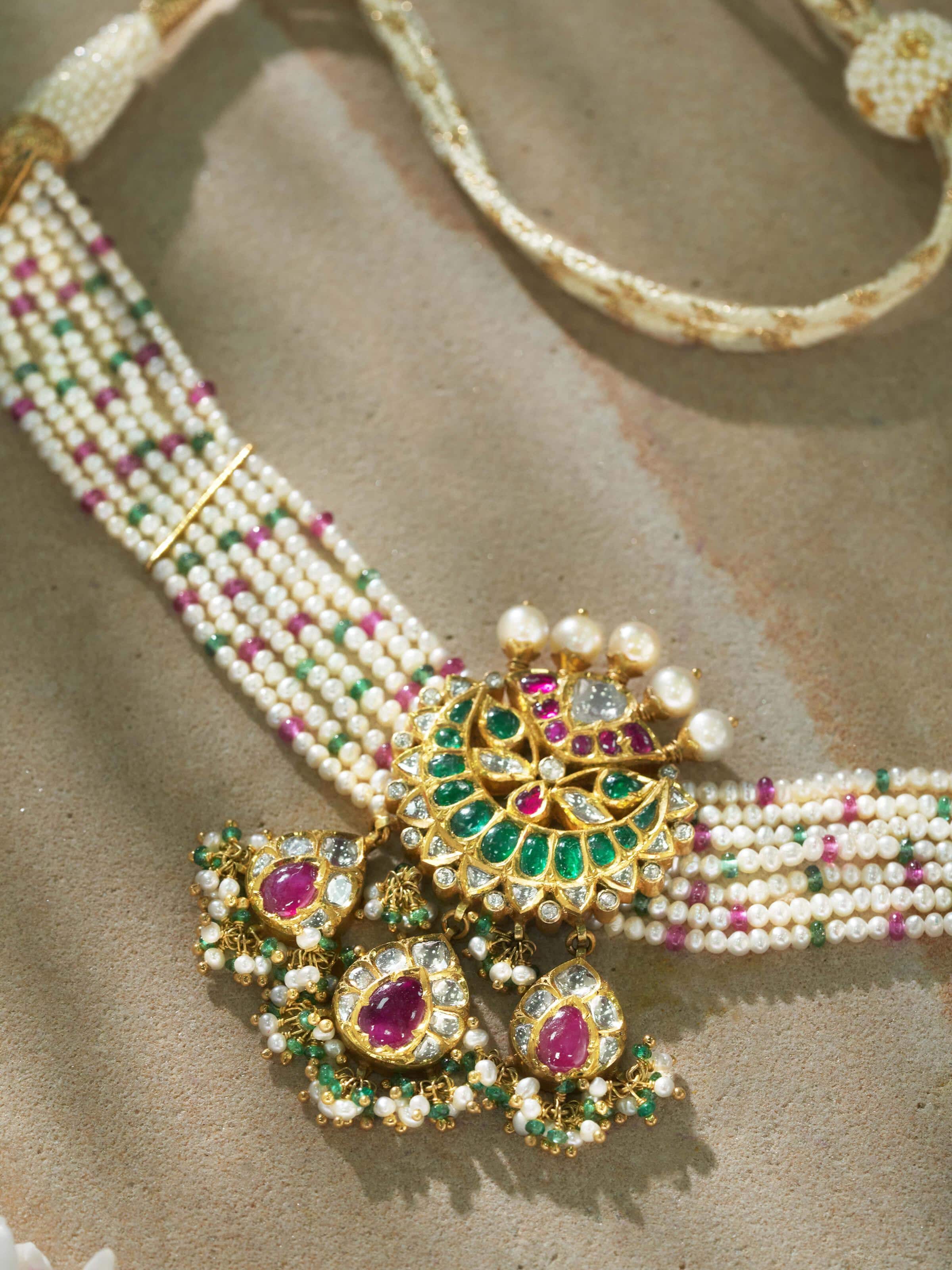 Angled view of Jadau 18K gold choker highlighting curved form and embedded stones.