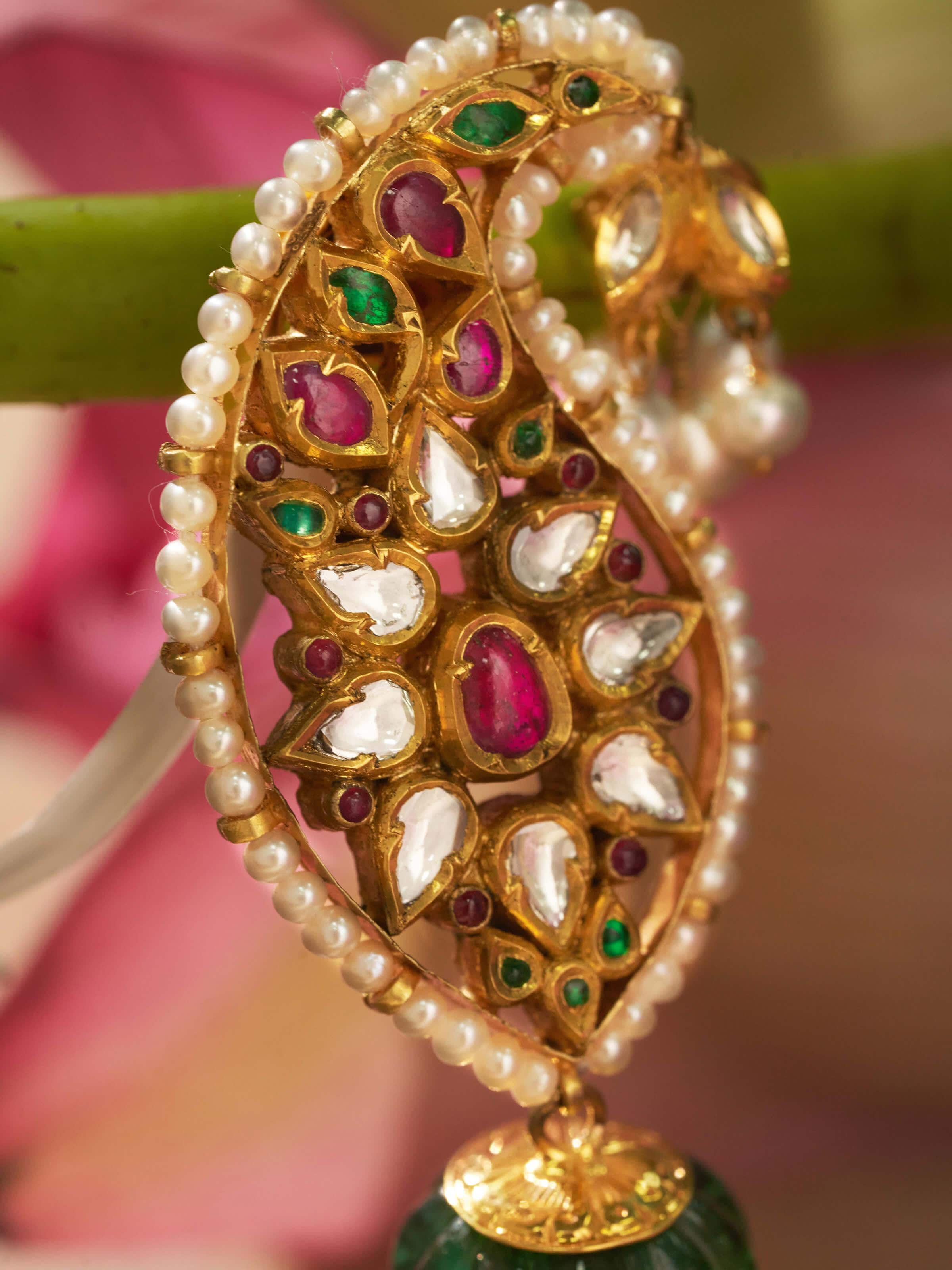 Close-up detail of enamel work and kundan stones on 18 Karat gold jhumkas