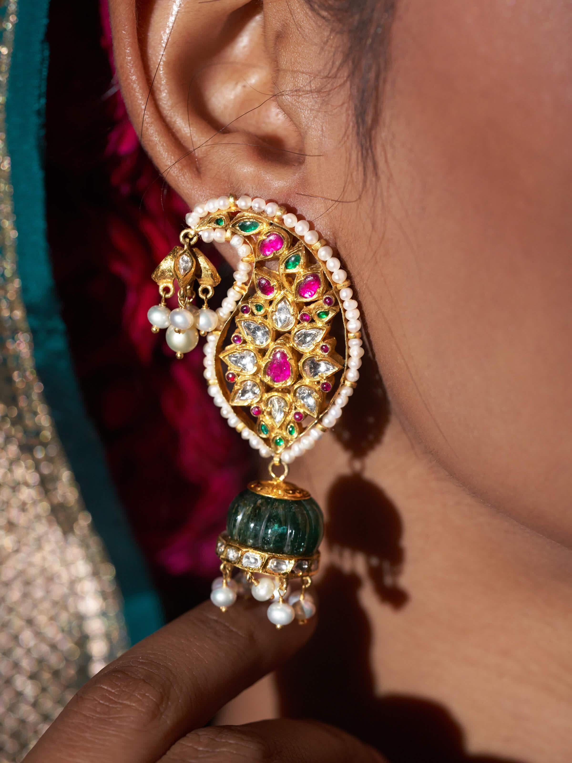 Backside close-up showing smooth gold finish and hook design of jhumkas
