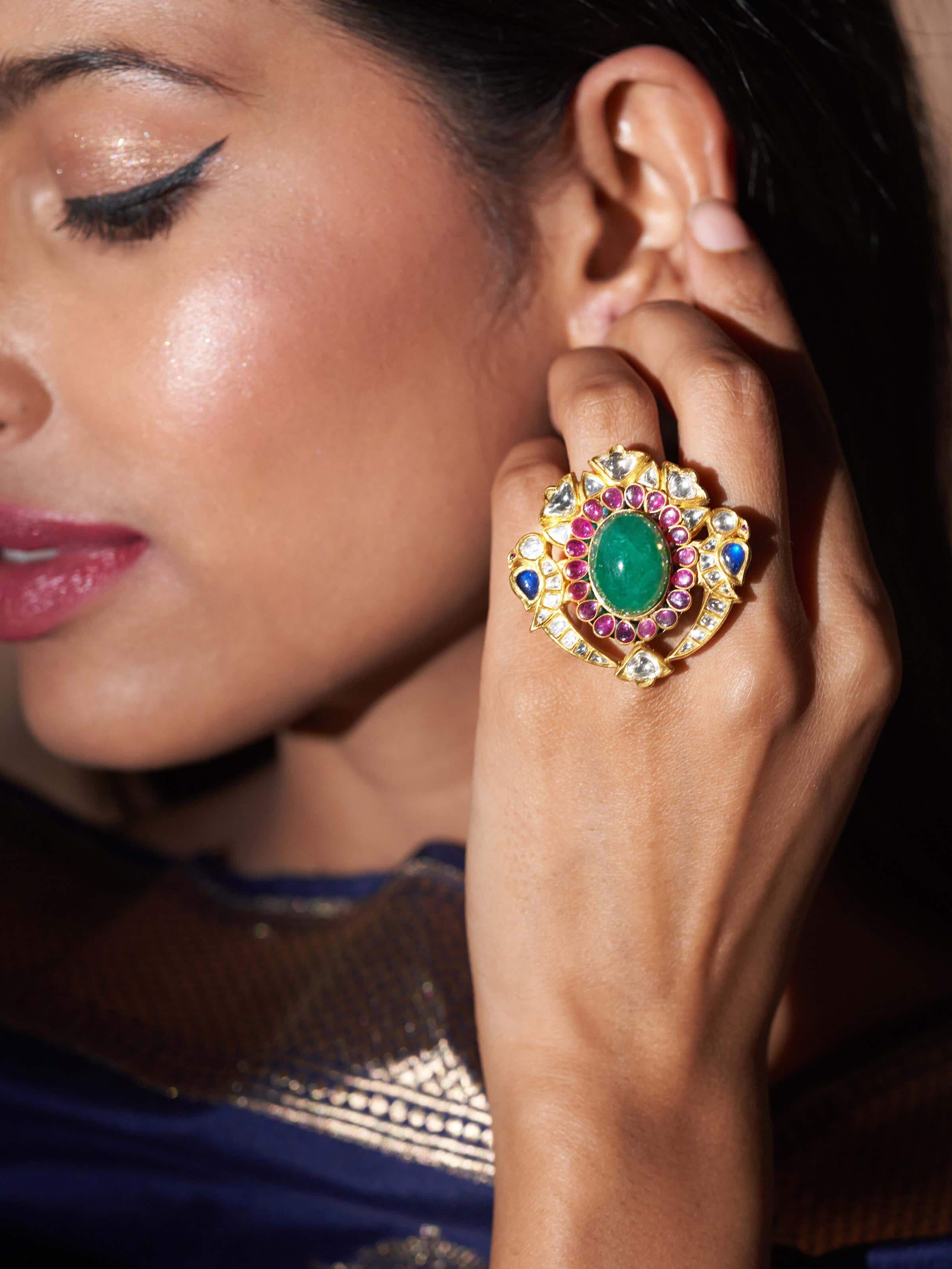 Lifestyle shot of gold Jadau ring worn on hand with ethnic ensemble