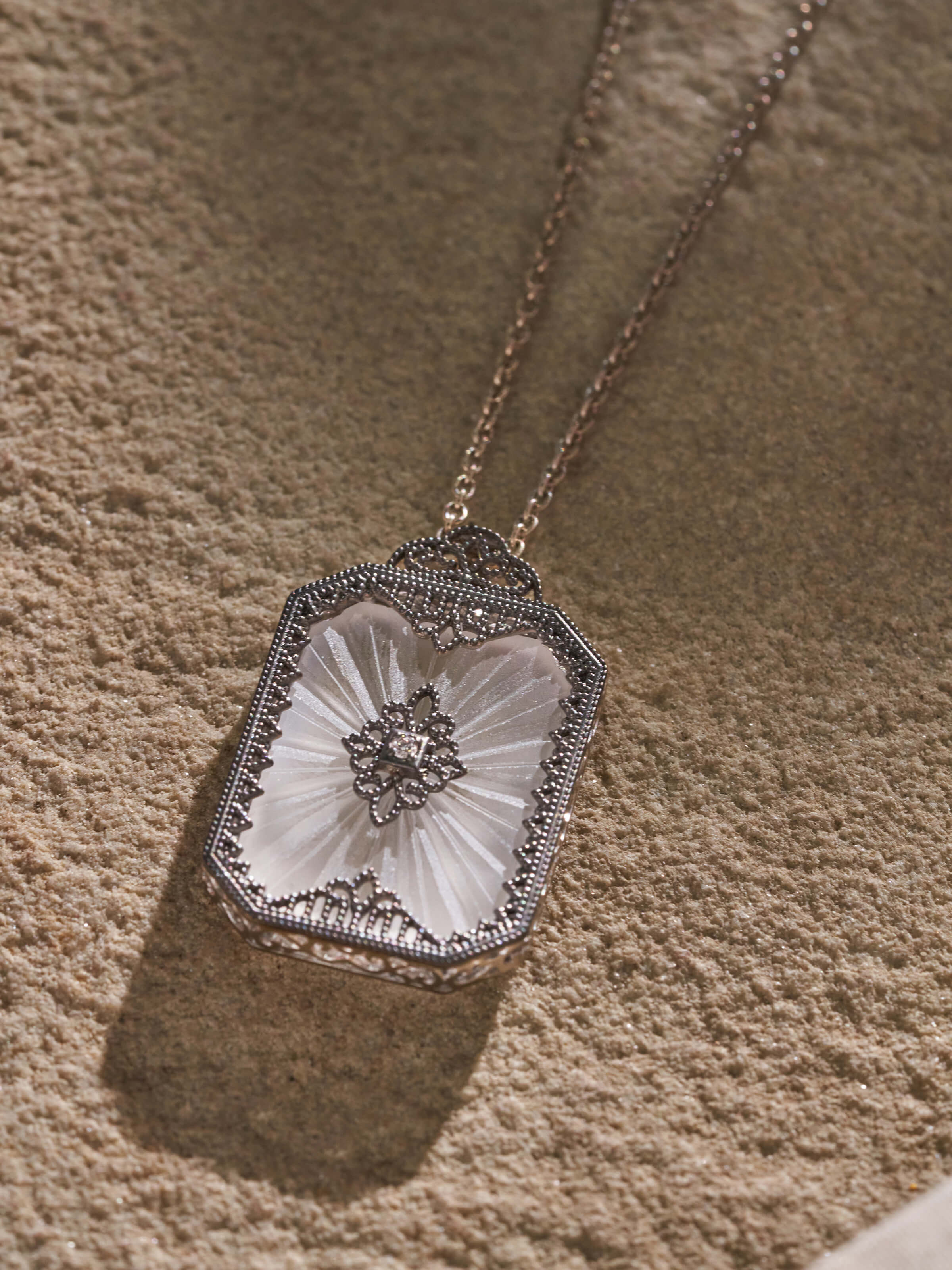 Close-up of Lapidary 14 Karat gold pendant and chain showing detailed goldwork.