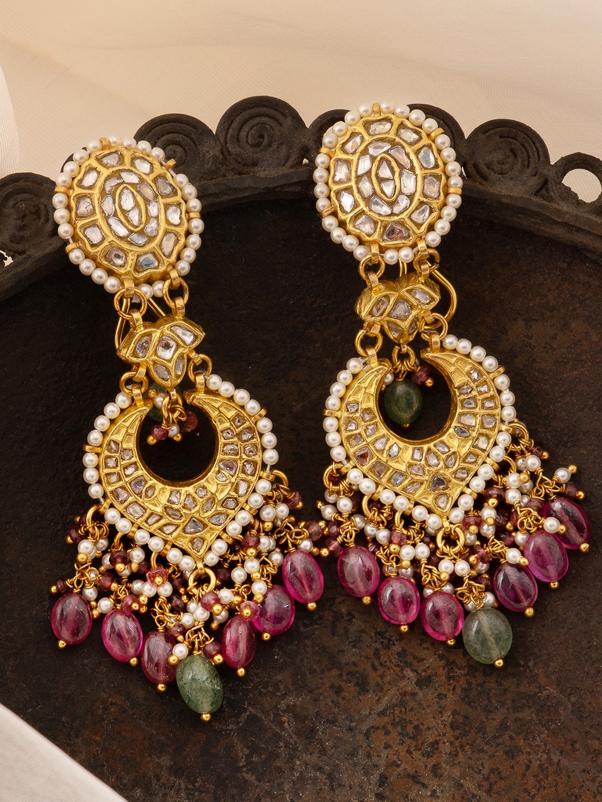 Angled view of Thappa 22 karat gold drop earrings focusing on intricate design and luxurious appearance
